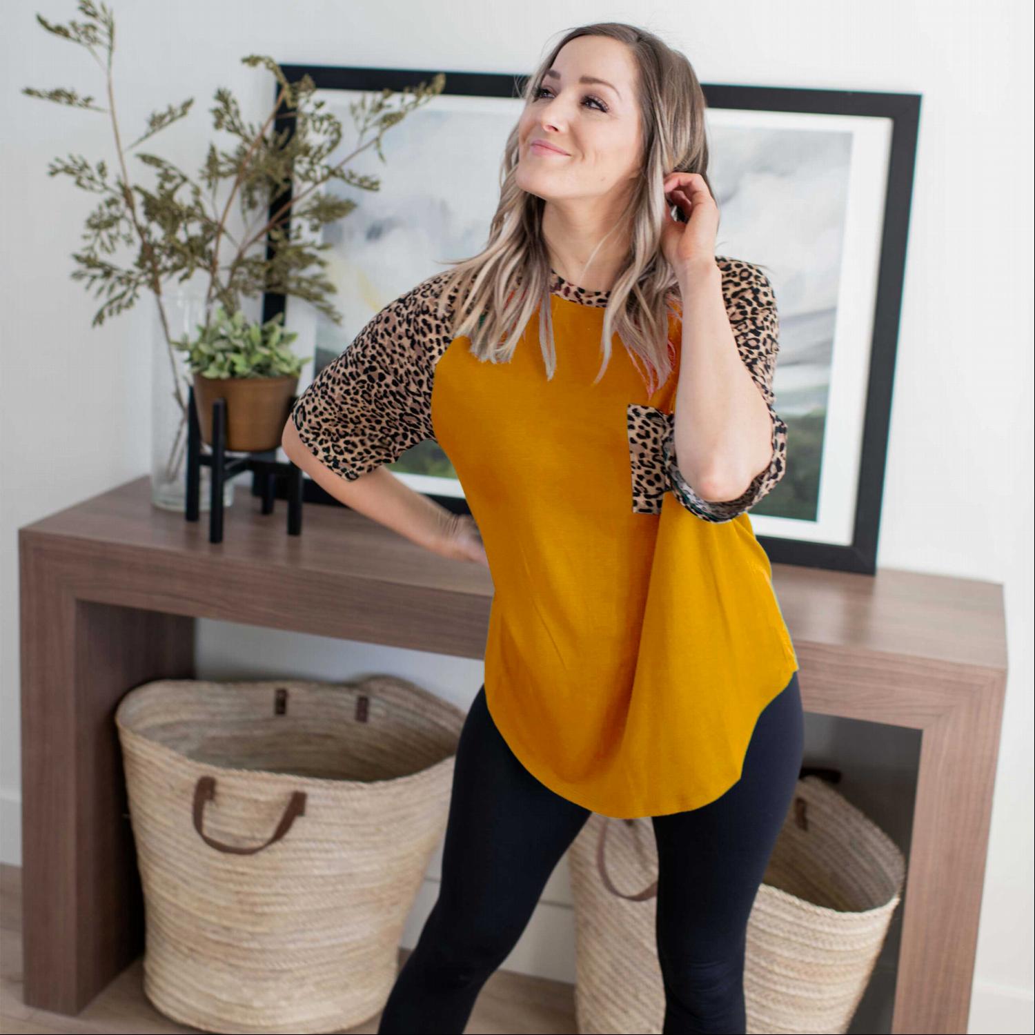 A stylish Bold Leopard Print Blouse featuring a relaxed fit, elbow-length sleeves, and a large chest pocket, with vibrant colors and leopard print details.