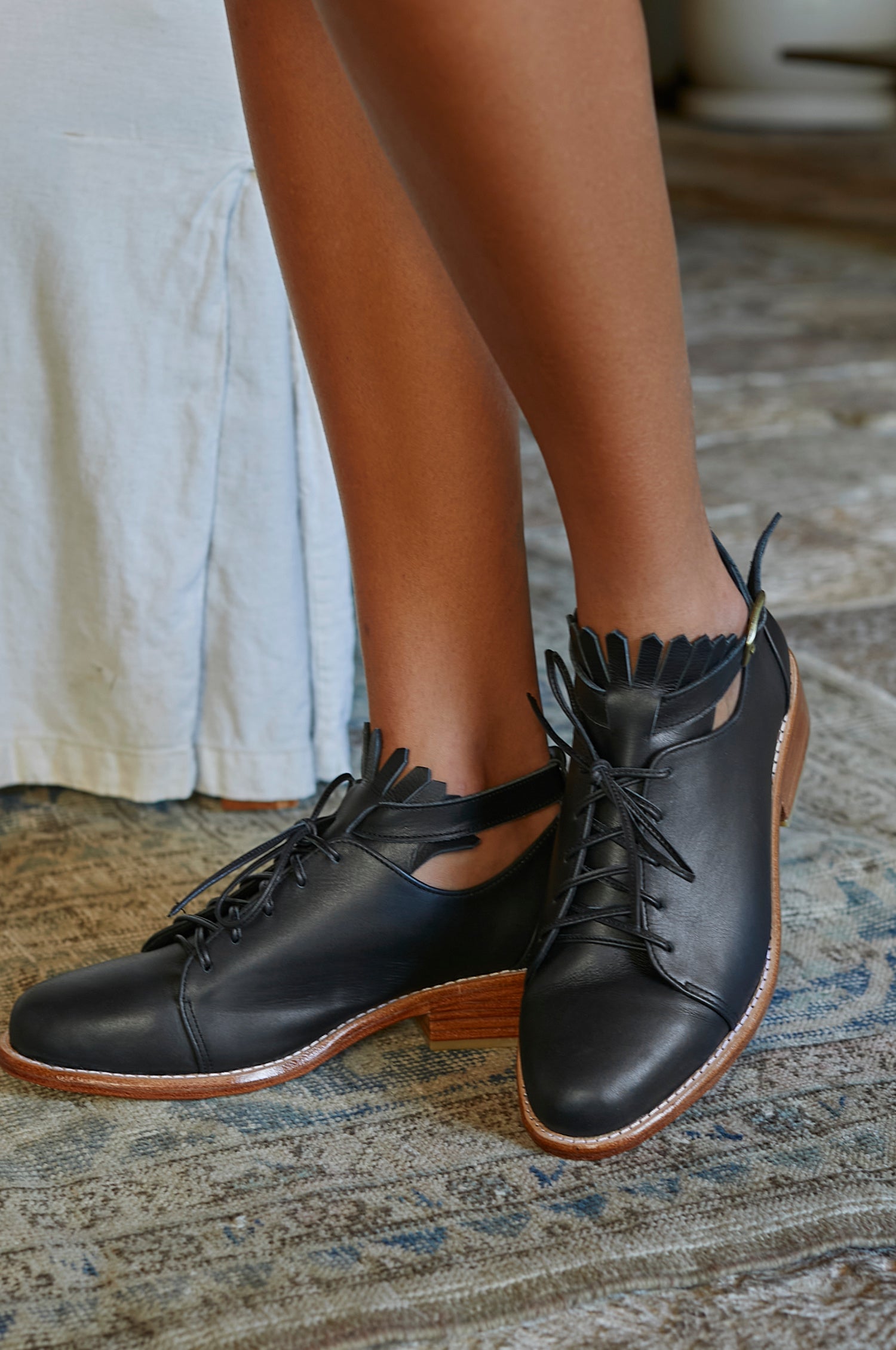 A pair of stylish Boston Leather Oxfords featuring fringe detailing and an ankle strap, made from genuine leather.