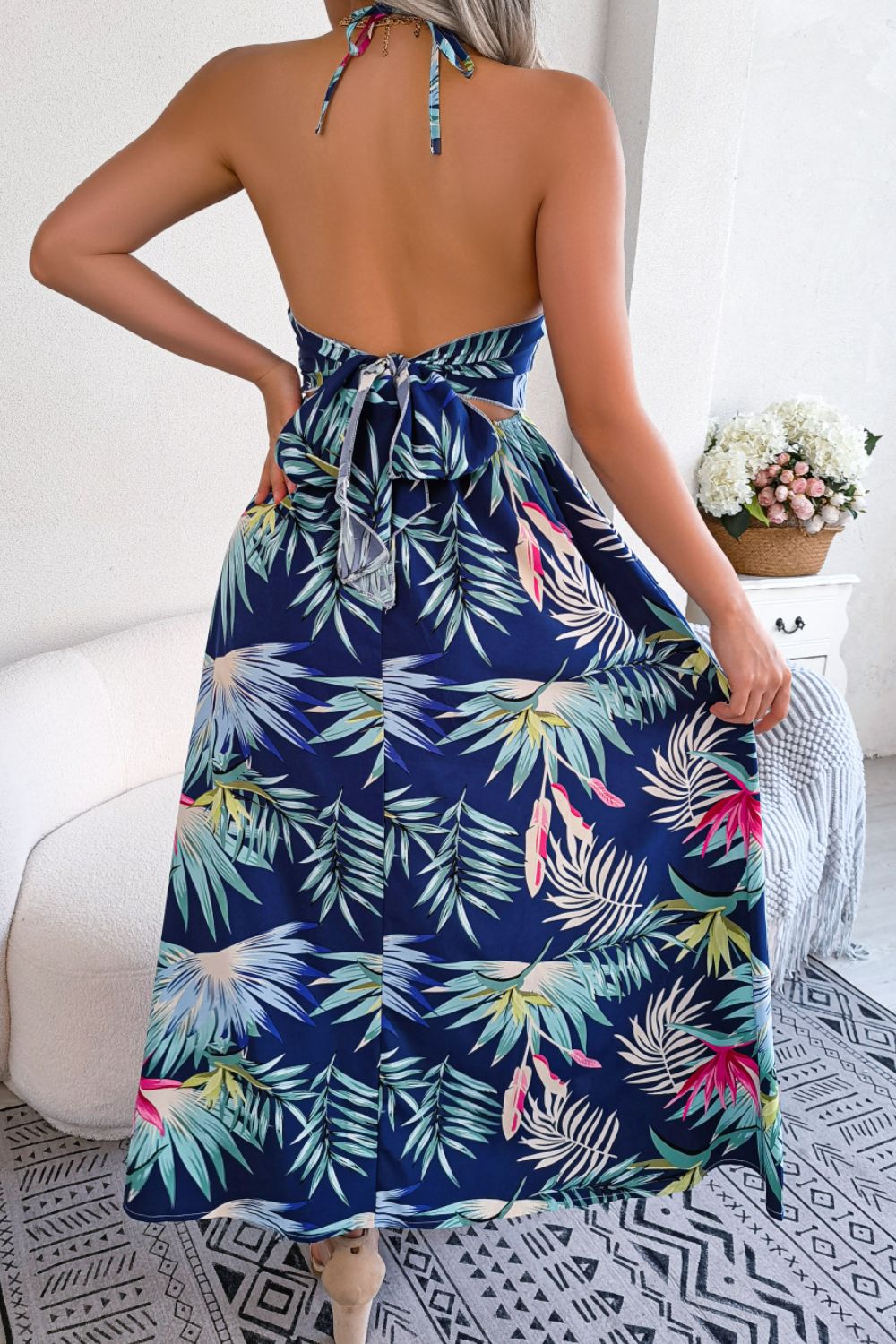 A stylish botanical print tied backless cutout slit dress, featuring a halter neck and flowing maxi length, perfect for casual and semi-formal occasions.