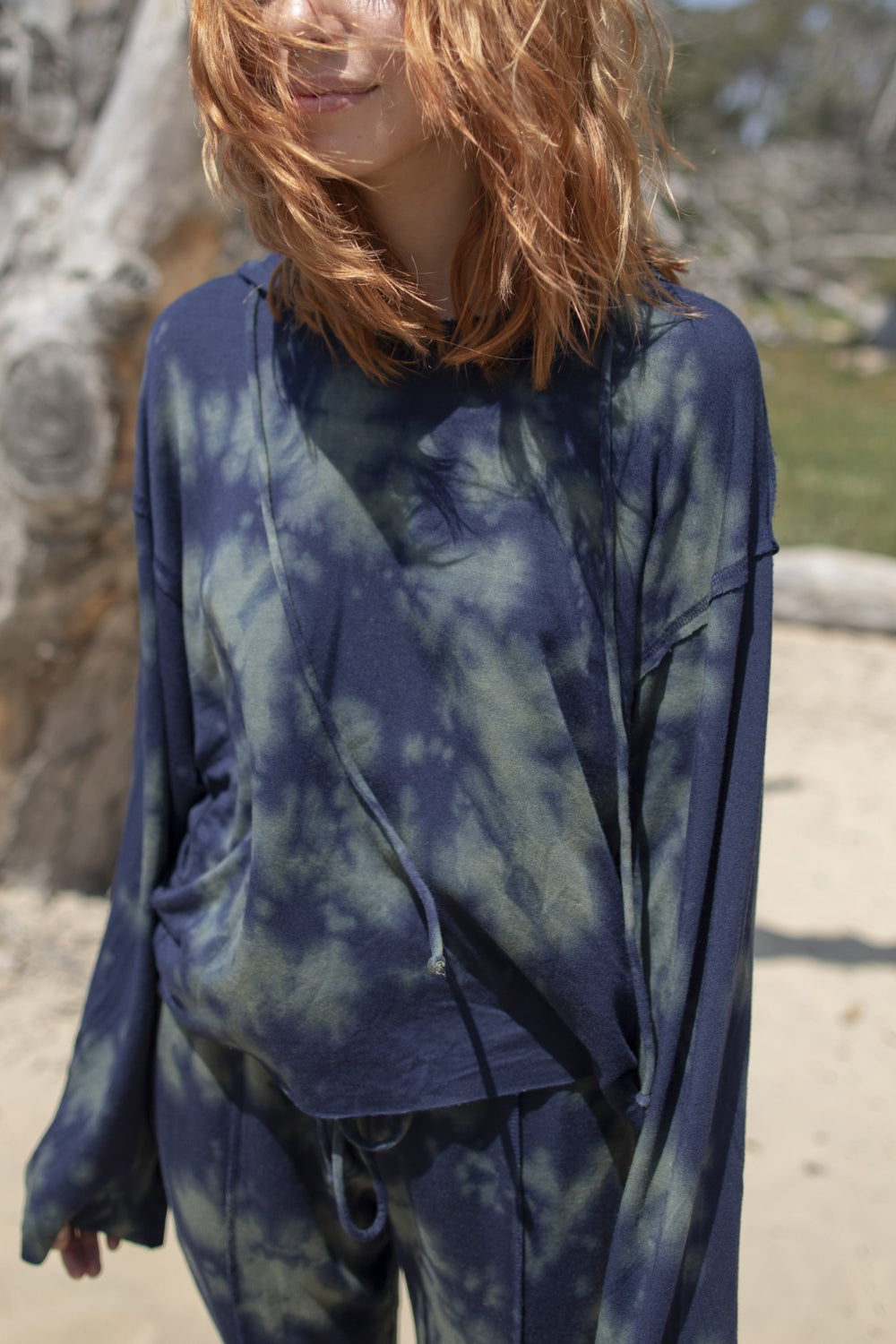 A stylish blue tie-dye boxy hoodie with raw hems and flared sleeves, perfect for casual wear.