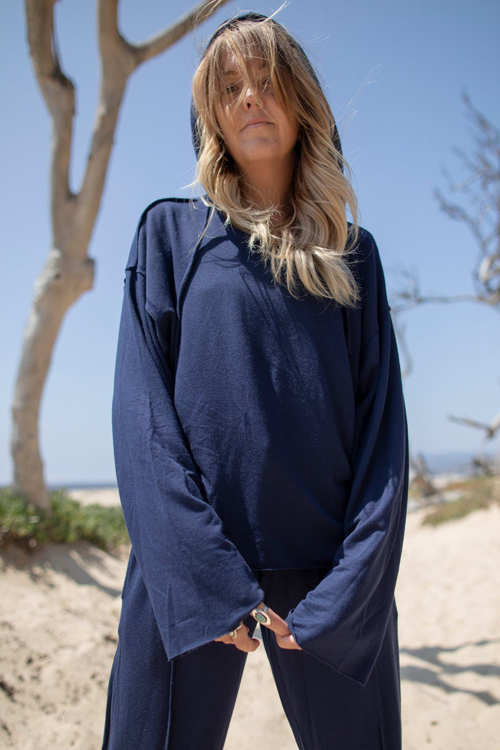 A stylish Boxy Hoodie featuring raw hems, exposed stitching, and a cropped fit, made from organic cotton and Tencel.