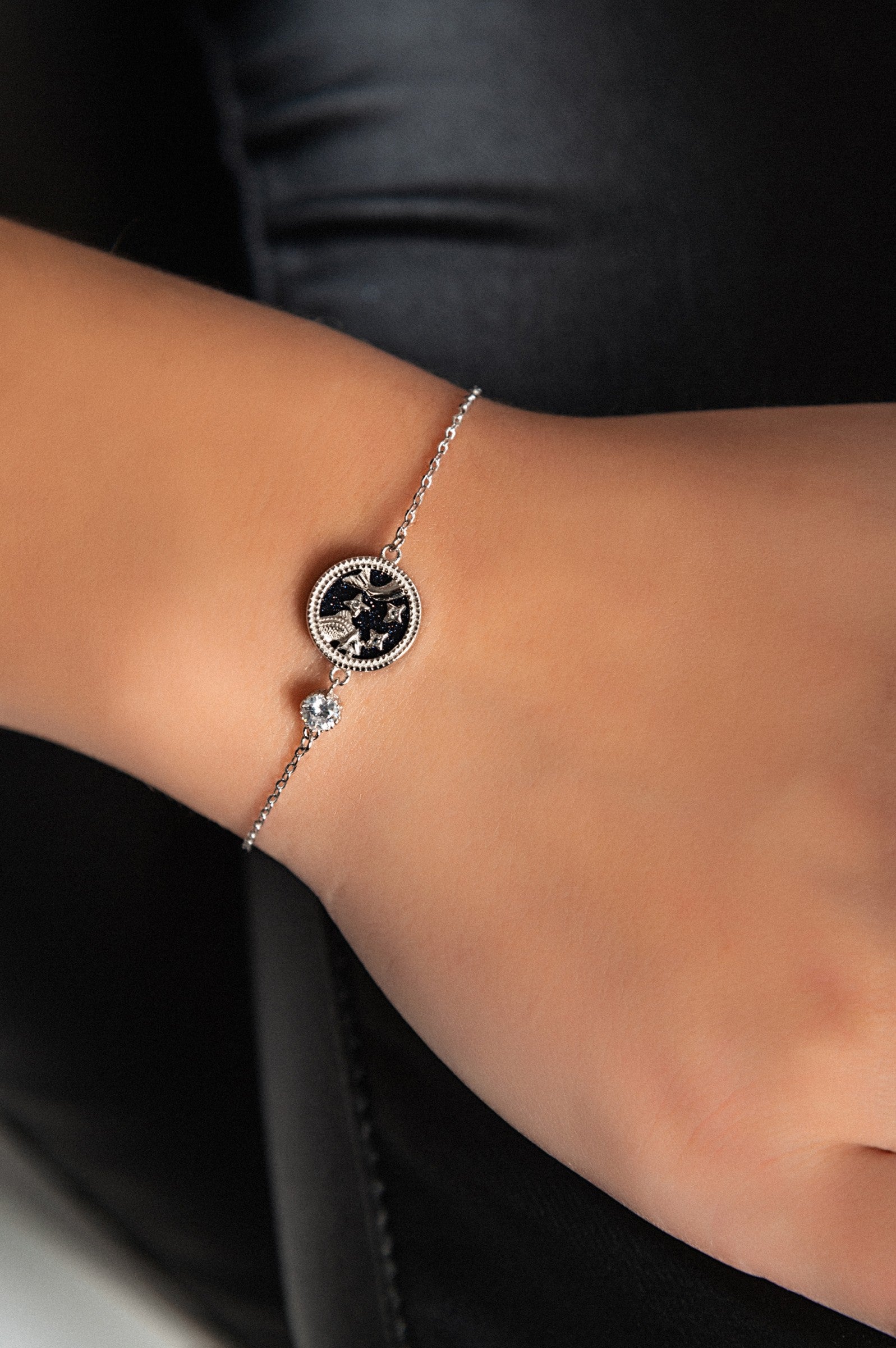 Elegant black bracelet with a silver PISCES pendant, showcasing a stylish design.