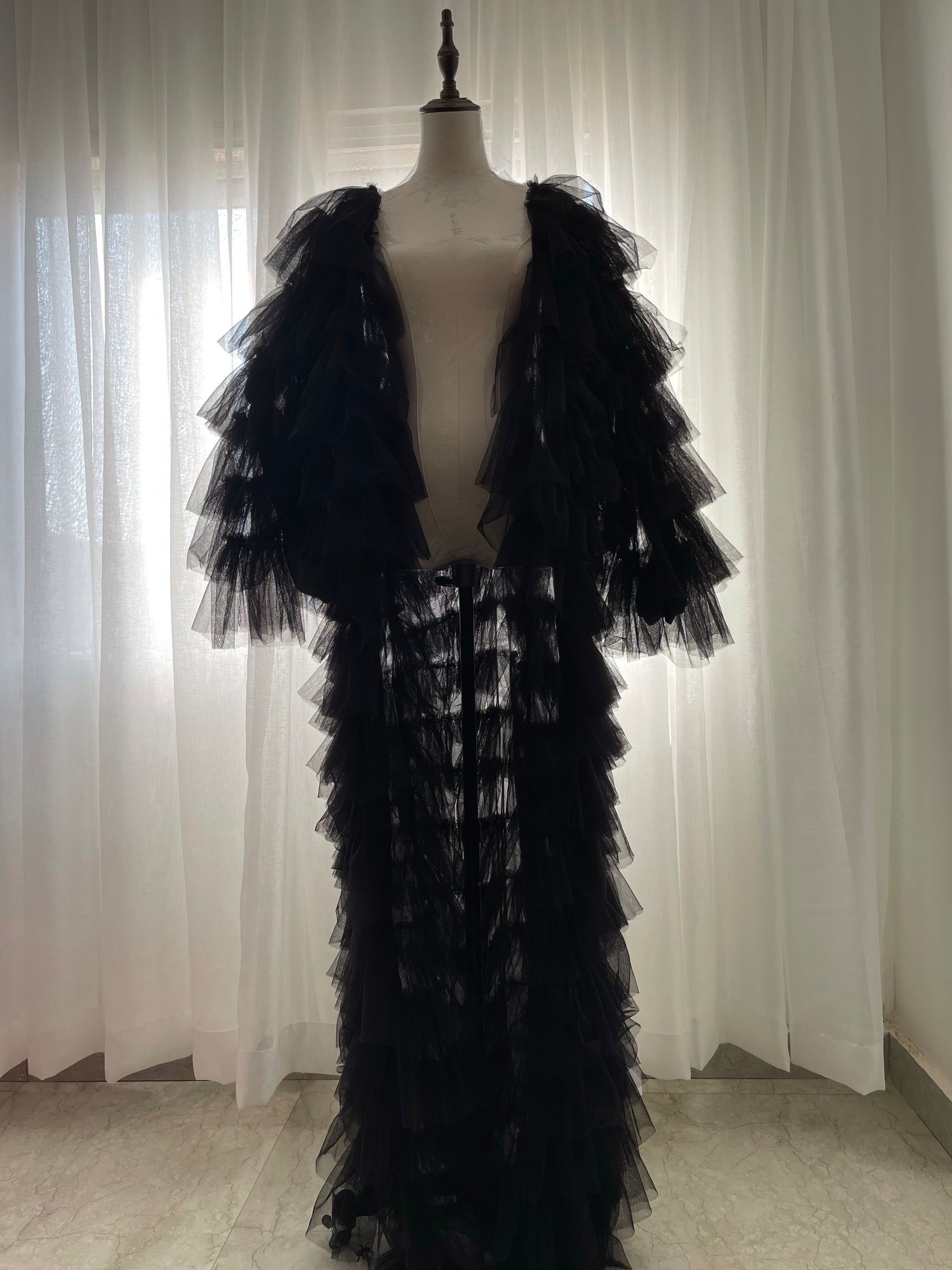 A stylish Breezy Long Coat made of soft ruffled tulle, elegantly draping over a mannequin.