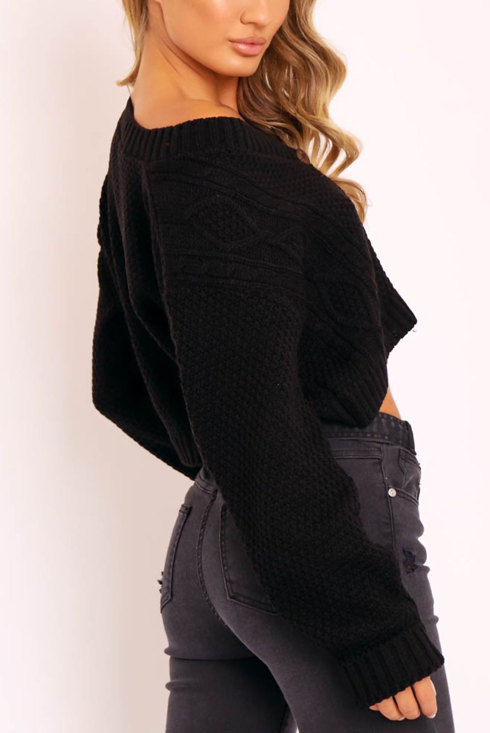 A stylish black cable knit cropped cardigan with button-up front, perfect for layering.