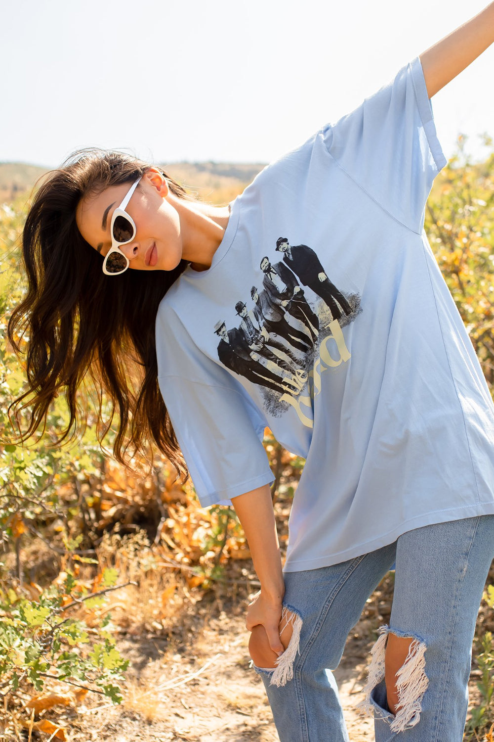 A blue oversized tee featuring a Cake graphic, made from 100% organic cotton, showcasing a relaxed fit and crewneck design.