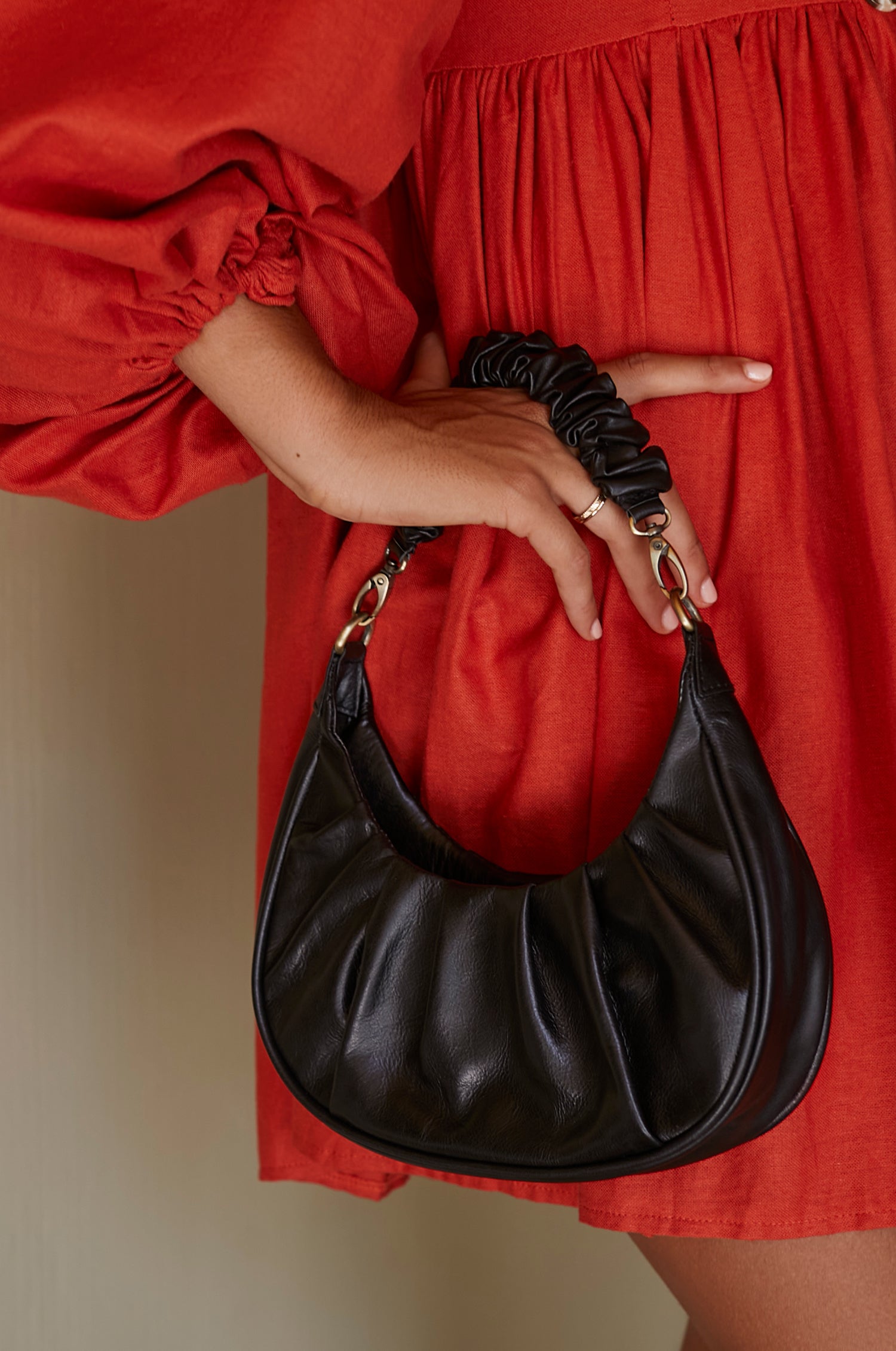 Camille Ruched Leather Bag in soft leather with a chic ruched design, featuring a detachable strap and secure magnetic closure.