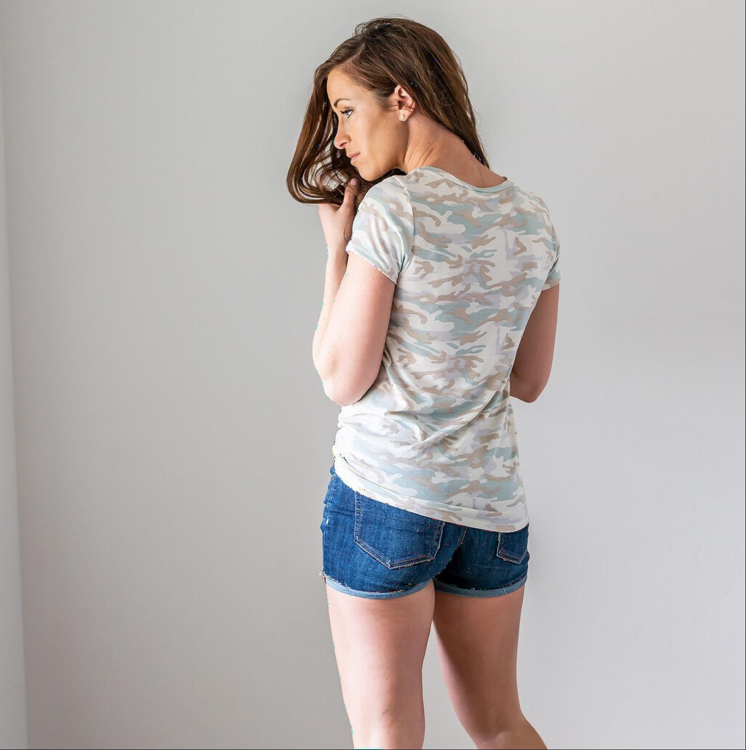 A stylish Camo V-Neck Top featuring a light camo print, short sleeves, and a front pocket, perfect for casual wear or as a beach cover-up.