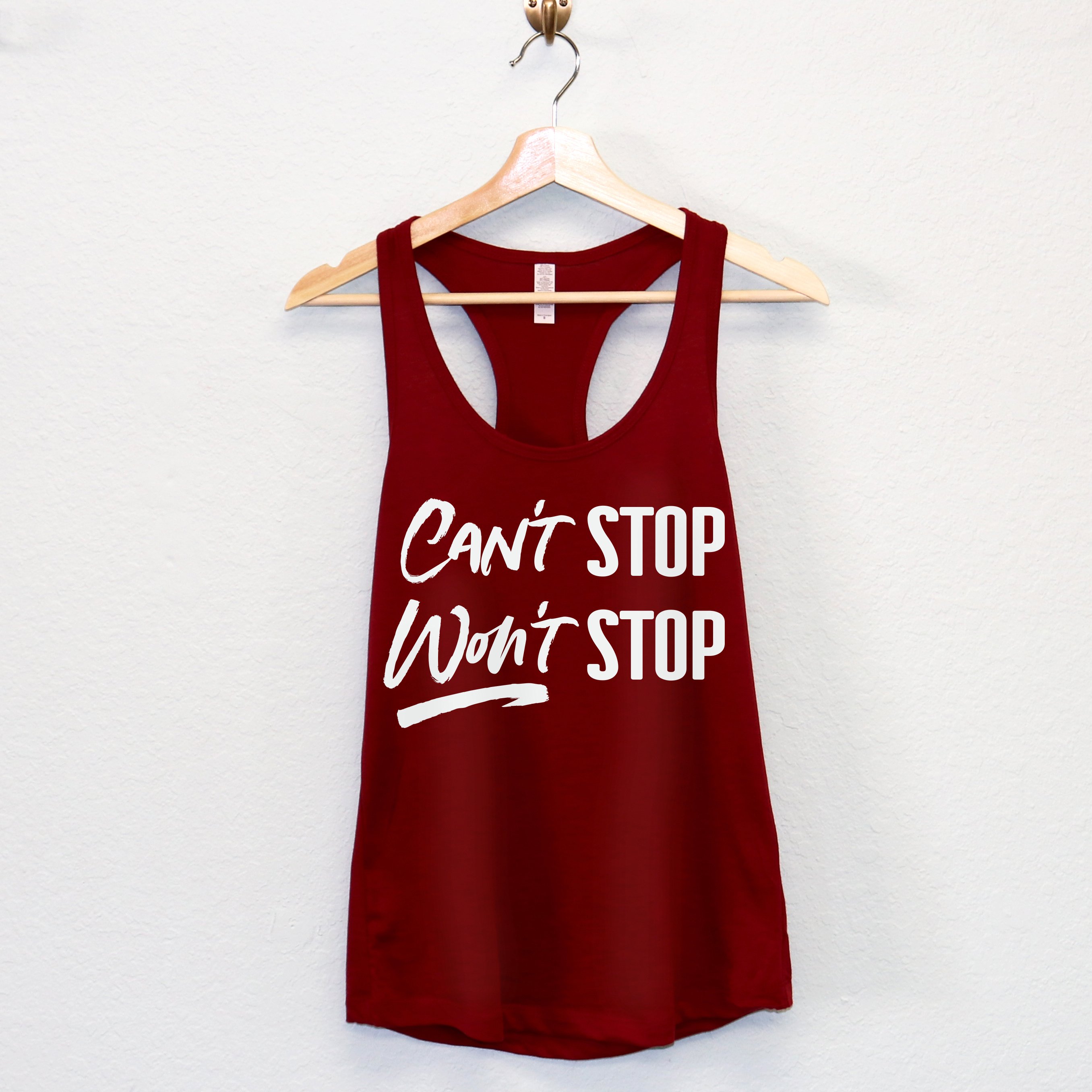 A stylish women's workout tank top featuring the motivational phrase 'CAN'T STOP WON'T STOP' in a racerback design, available in multiple colors.