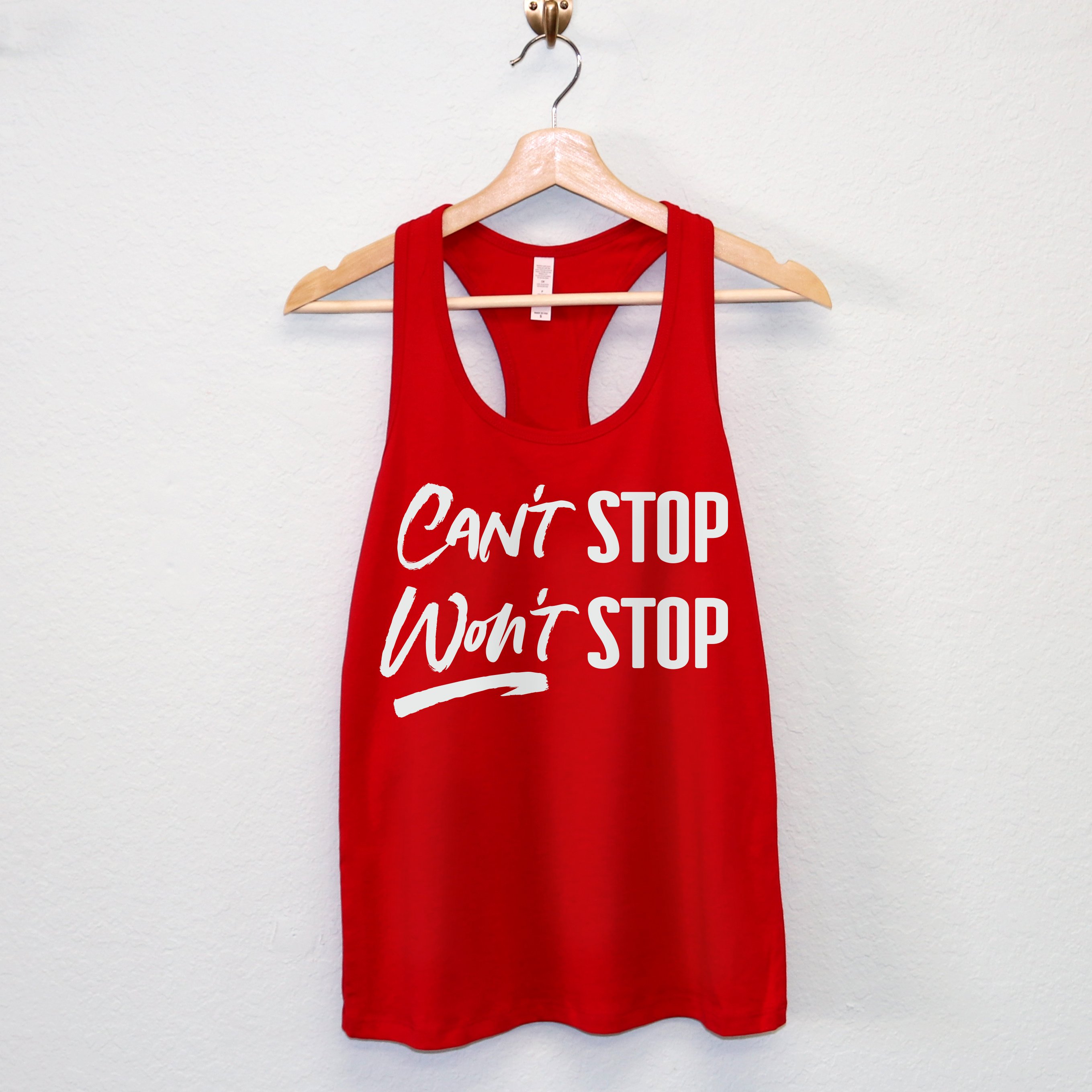 A stylish women's workout tank top featuring the motivational phrase 'CAN'T STOP WON'T STOP' in a racerback design, available in multiple colors.