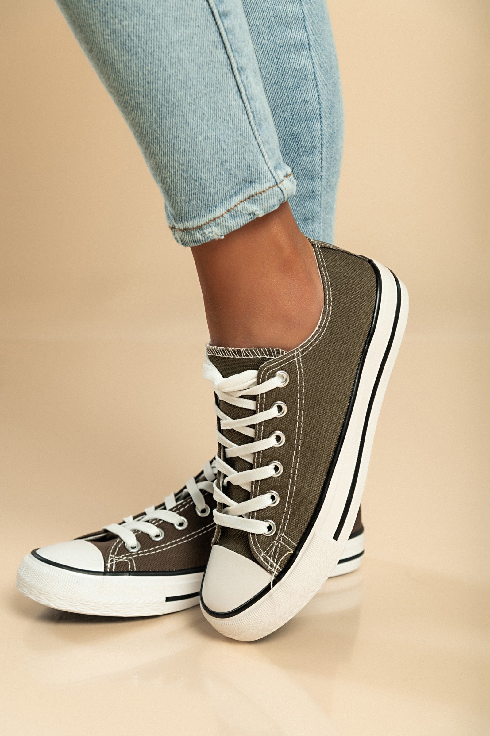 A pair of military green canvas sneakers featuring a round plastic toe and lace-up fastening, perfect for casual wear.