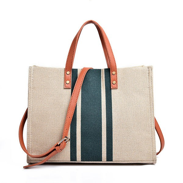 Stylish Canvas Stripe Tote with gold grommet detail and removable crossbody strap, showcasing its spacious design and multiple pockets.