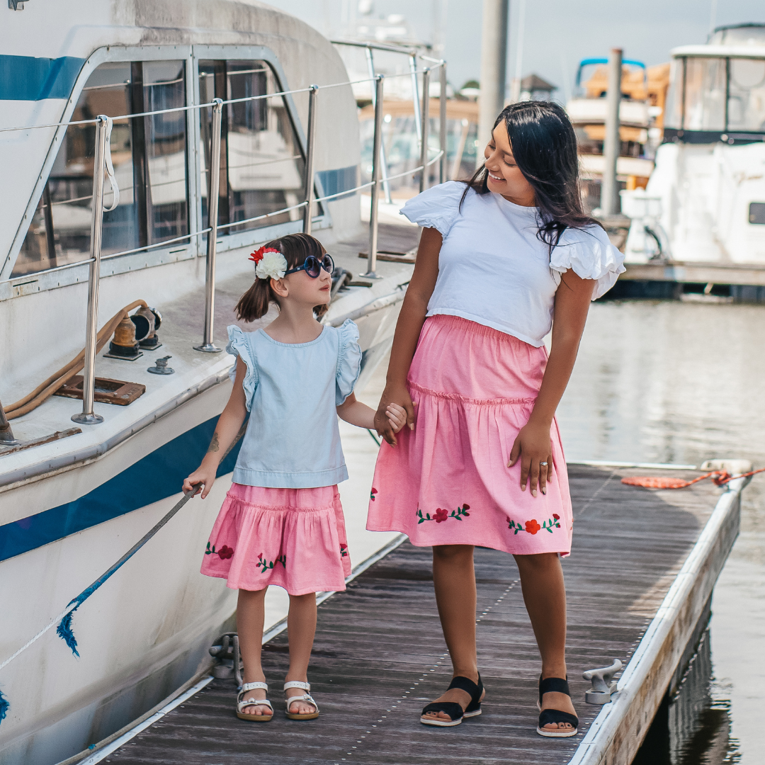 The Cari Skirt featuring intricate hand embroidery on pink chambray fabric, showcasing traditional artisan craftsmanship from Oaxaca, Mexico.