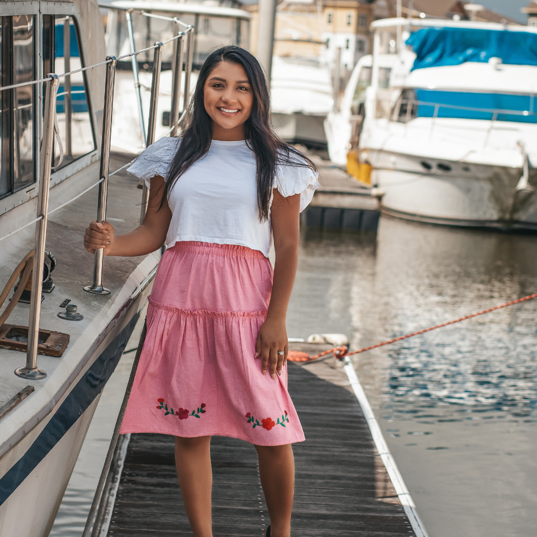 The Cari Skirt featuring intricate hand embroidery on pink chambray fabric, showcasing traditional artisan craftsmanship from Oaxaca, Mexico.