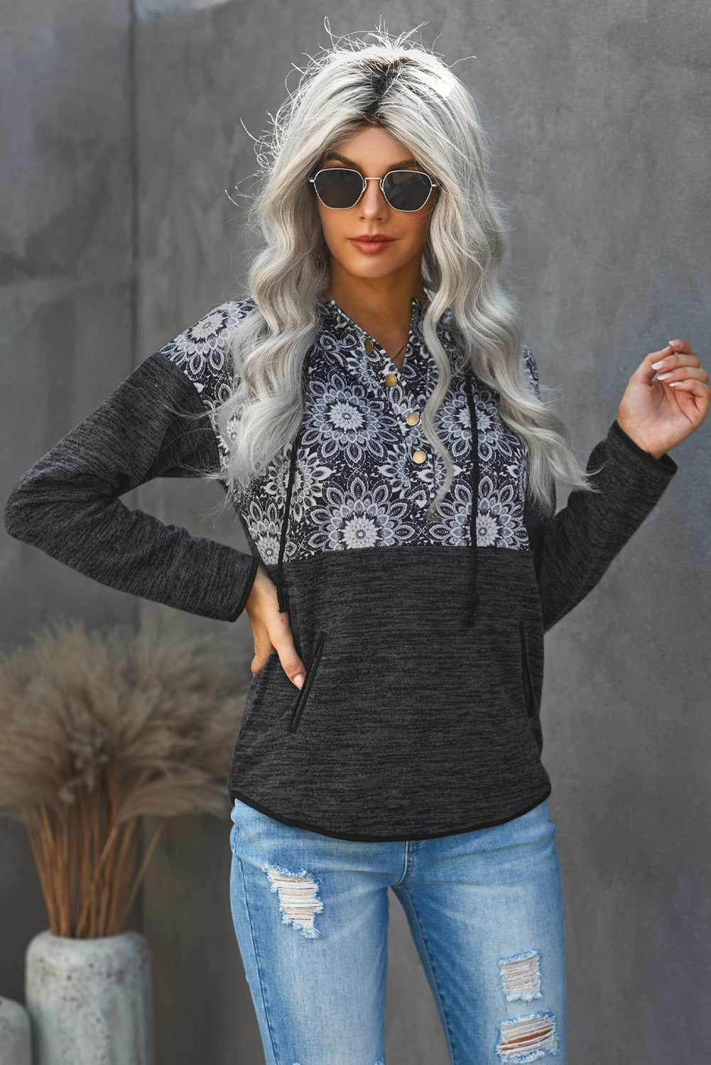 Casual black hoodie featuring a vintage tribal print, adjustable buttons at the neckline, and a practical pocket, perfect for casual wear.