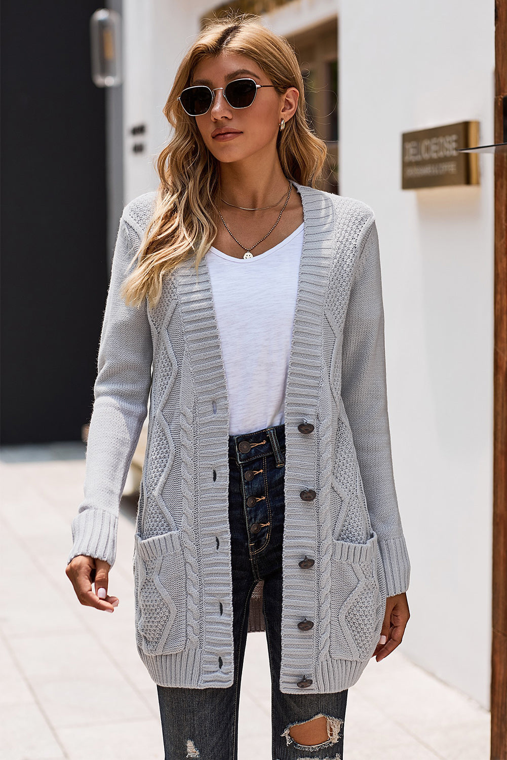 Casual gray cardigan with front pockets and button closure, showcasing a unique knit pattern, perfect for winter wear.