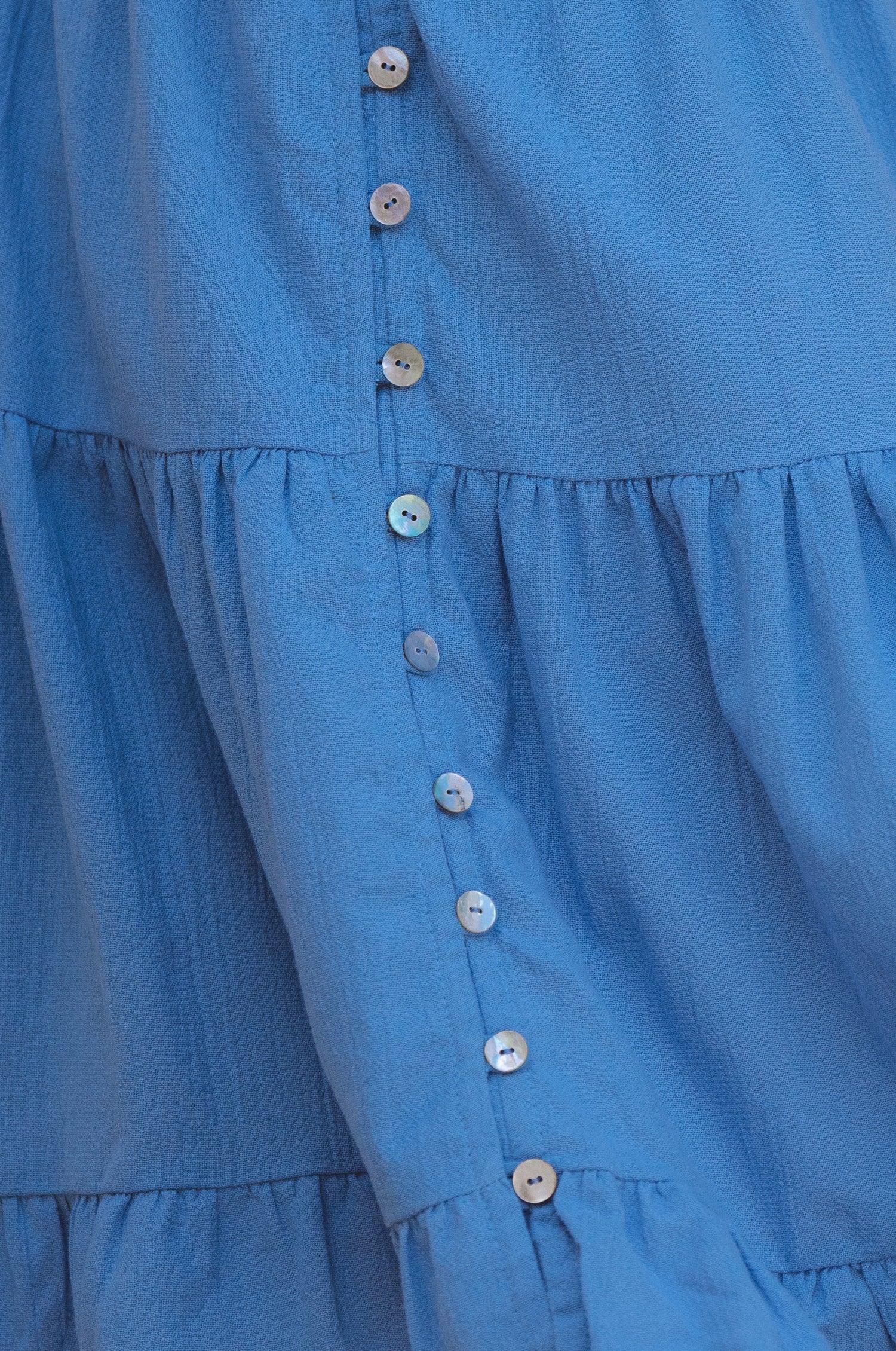 Catalina Smocked Linen Mini Dress featuring a smocked bodice, ruffles, and petite shell buttons in a summery color.