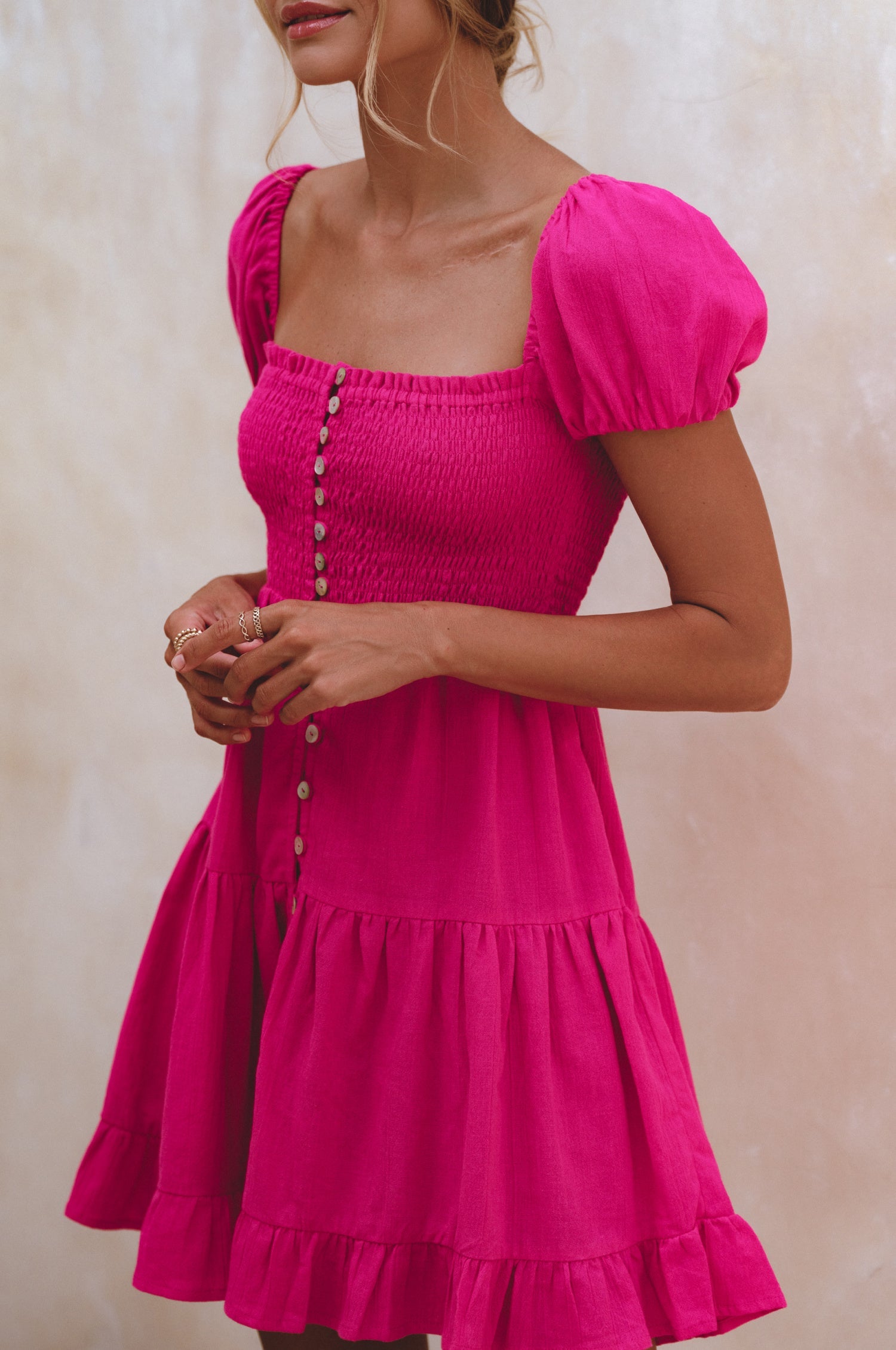 Catalina Smocked Linen Mini Dress featuring a smocked bodice, ruffles, and petite shell buttons in a summery color.