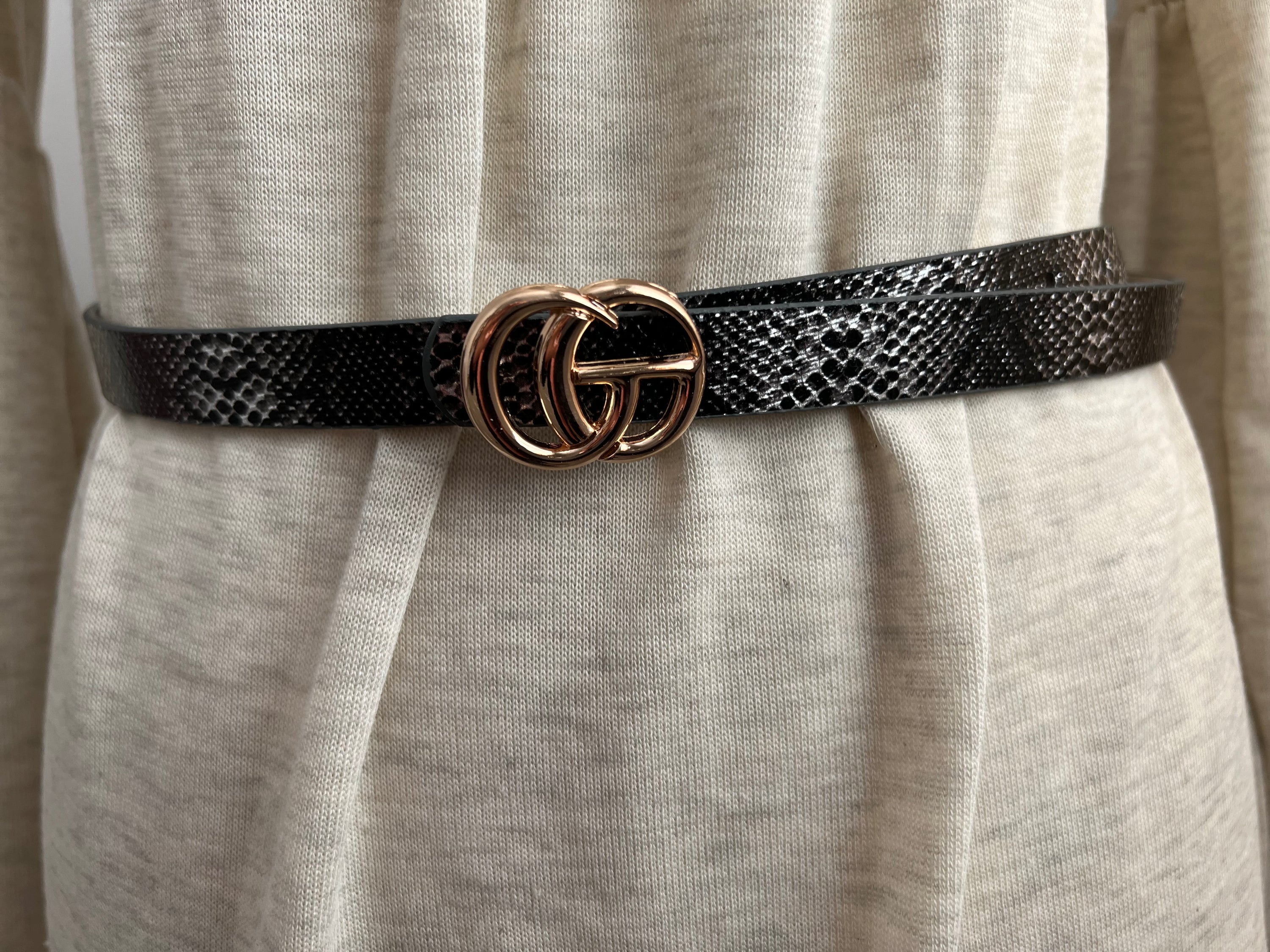 A stylish CG inspired snakeskin belt, 5/8” wide, adjustable fit for sizes up to 2x, showcasing a unique snakeskin pattern.