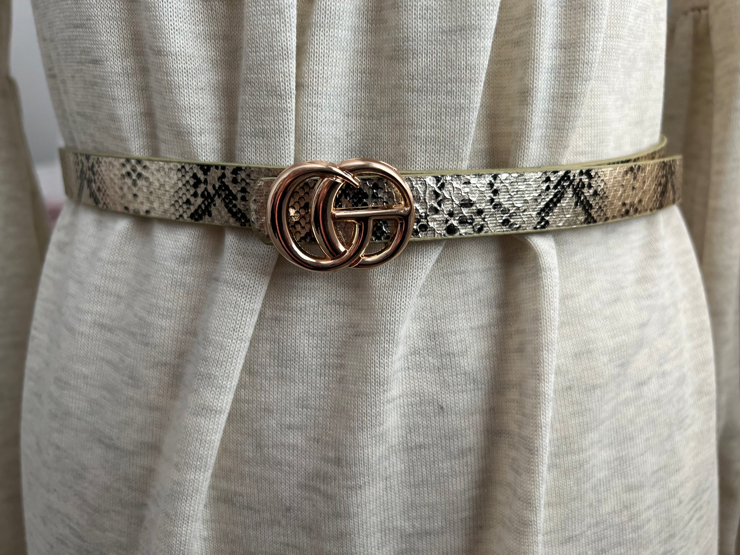 A stylish CG inspired snakeskin belt, 5/8” wide, adjustable fit for sizes up to 2x, showcasing a unique snakeskin pattern.