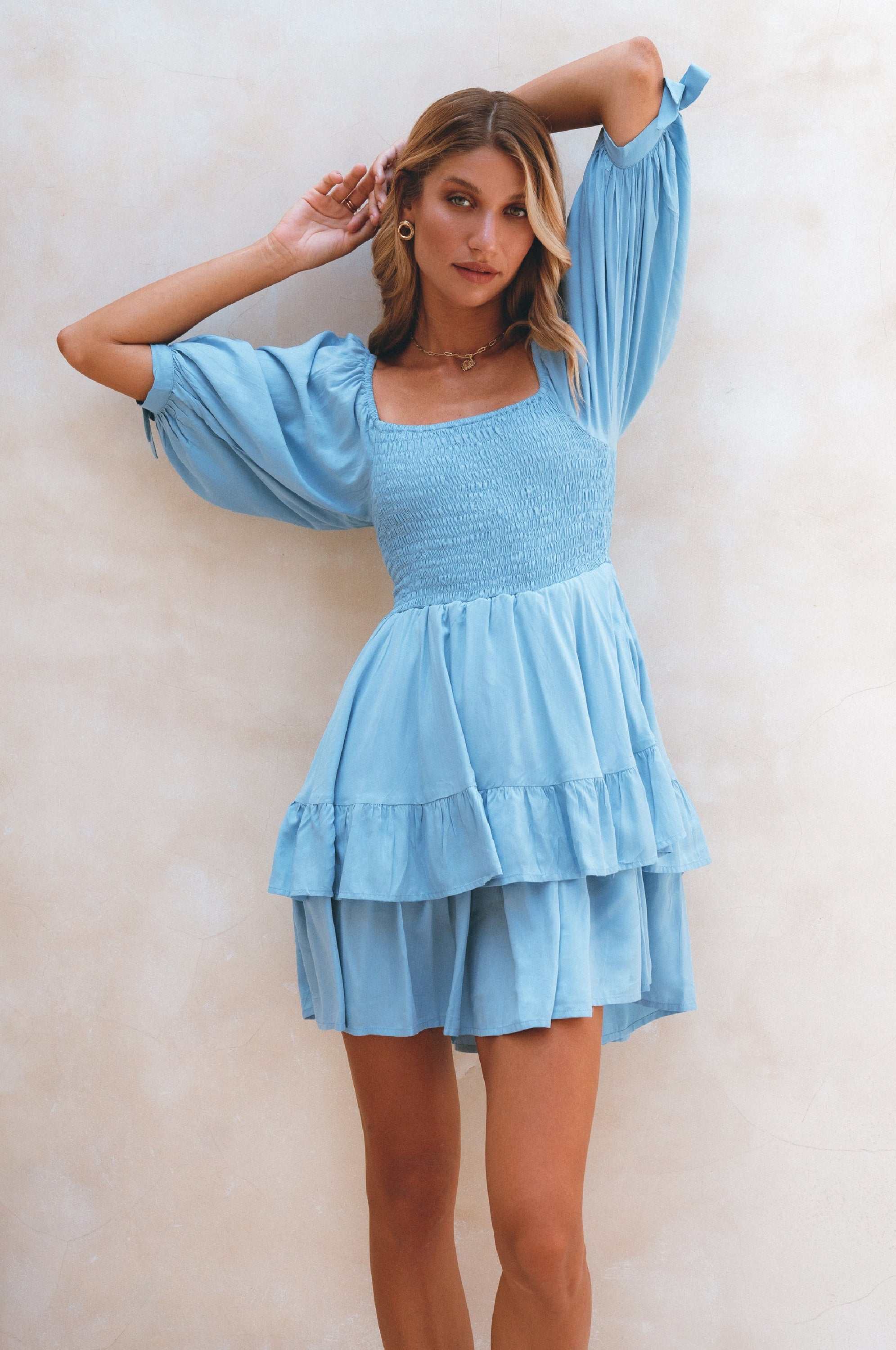 A stylish Cha-Cha Ruffle Mini Dress featuring a smocked bodice, ruffled trim, and billowing sleeves, perfect for summer outings.