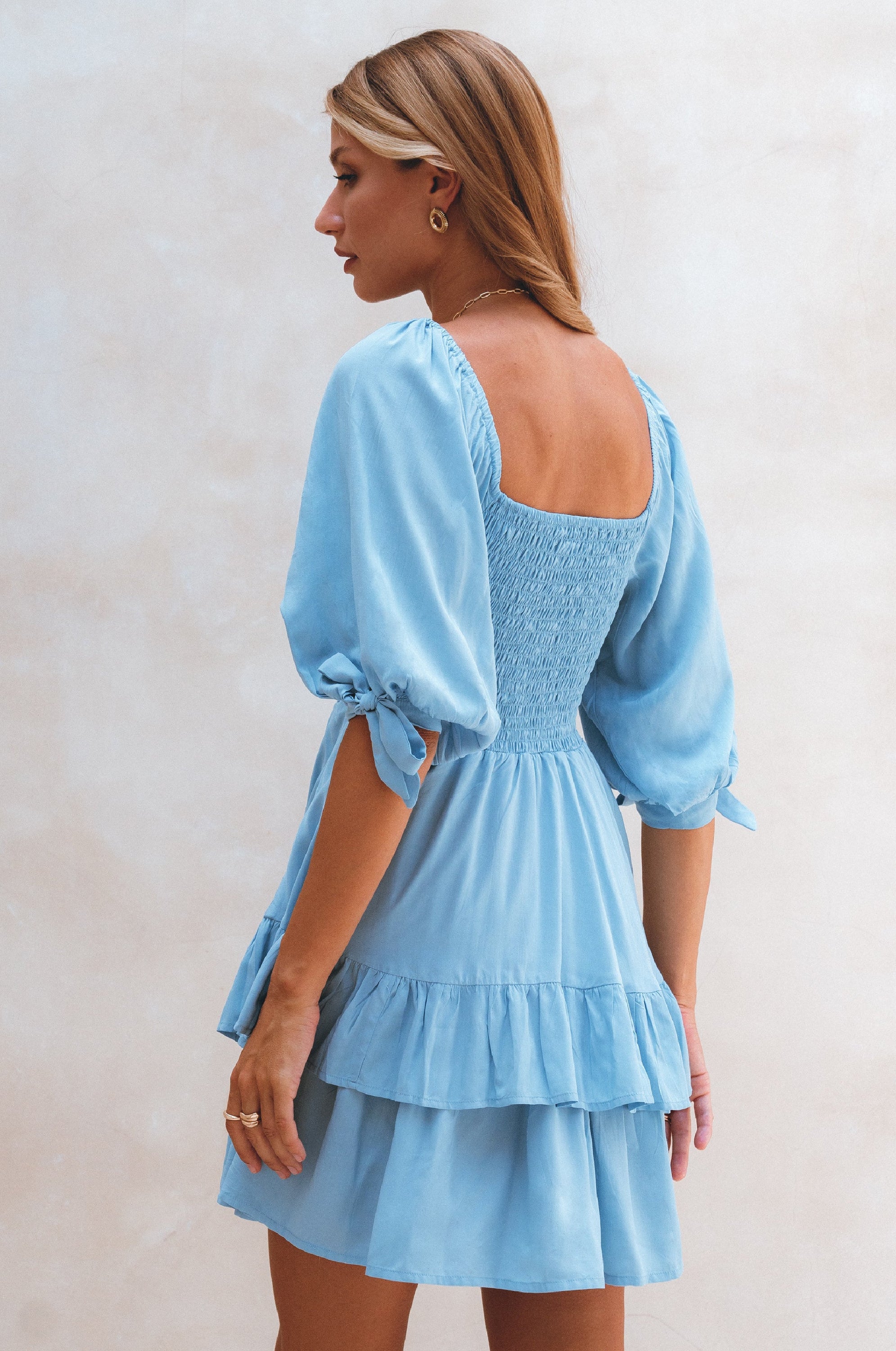 A stylish Cha-Cha Ruffle Mini Dress featuring a smocked bodice, ruffled trim, and billowing sleeves, perfect for summer outings.