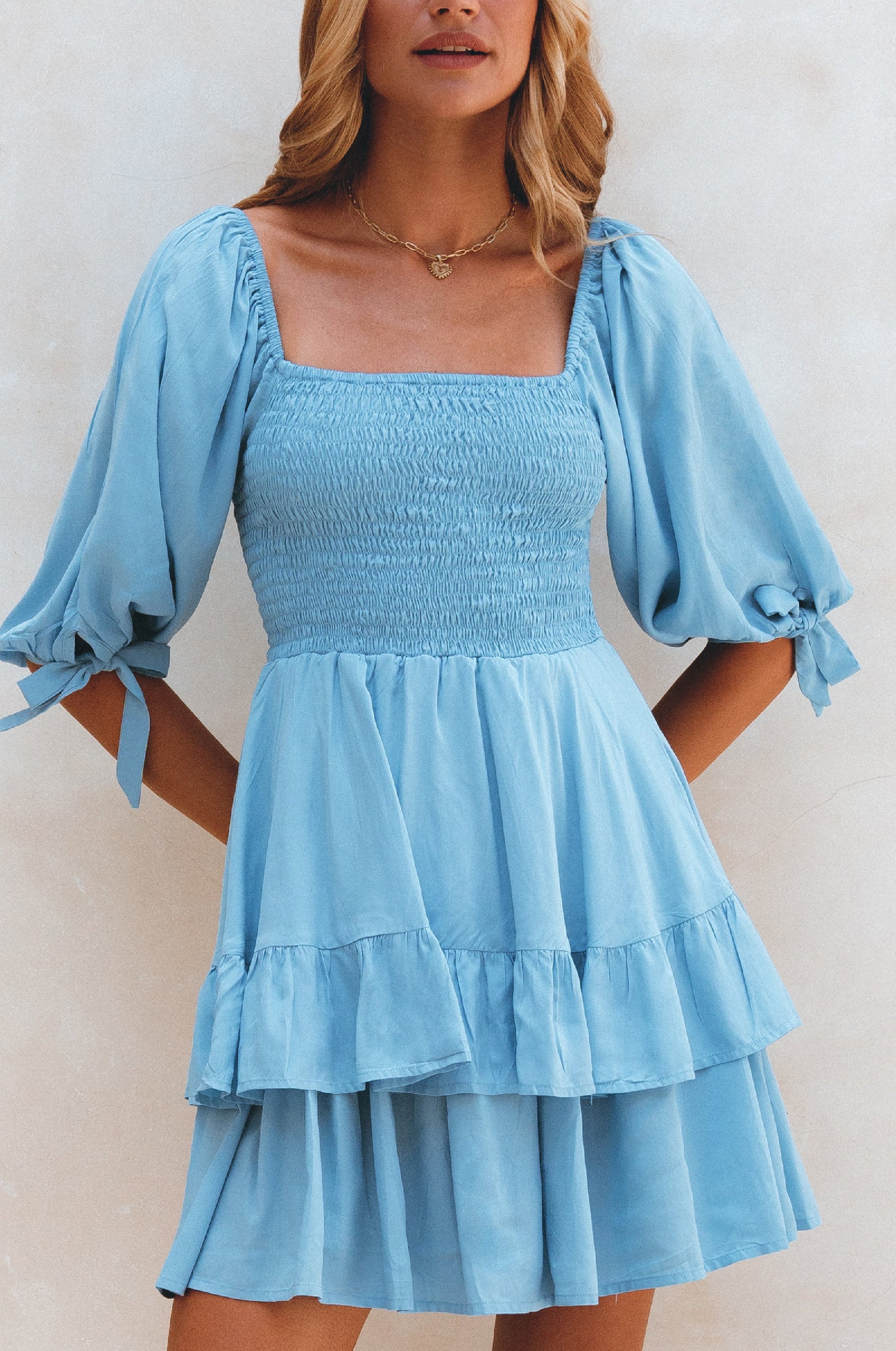 A stylish Cha-Cha Ruffle Mini Dress featuring a smocked bodice, ruffled trim, and billowing sleeves, perfect for summer outings.