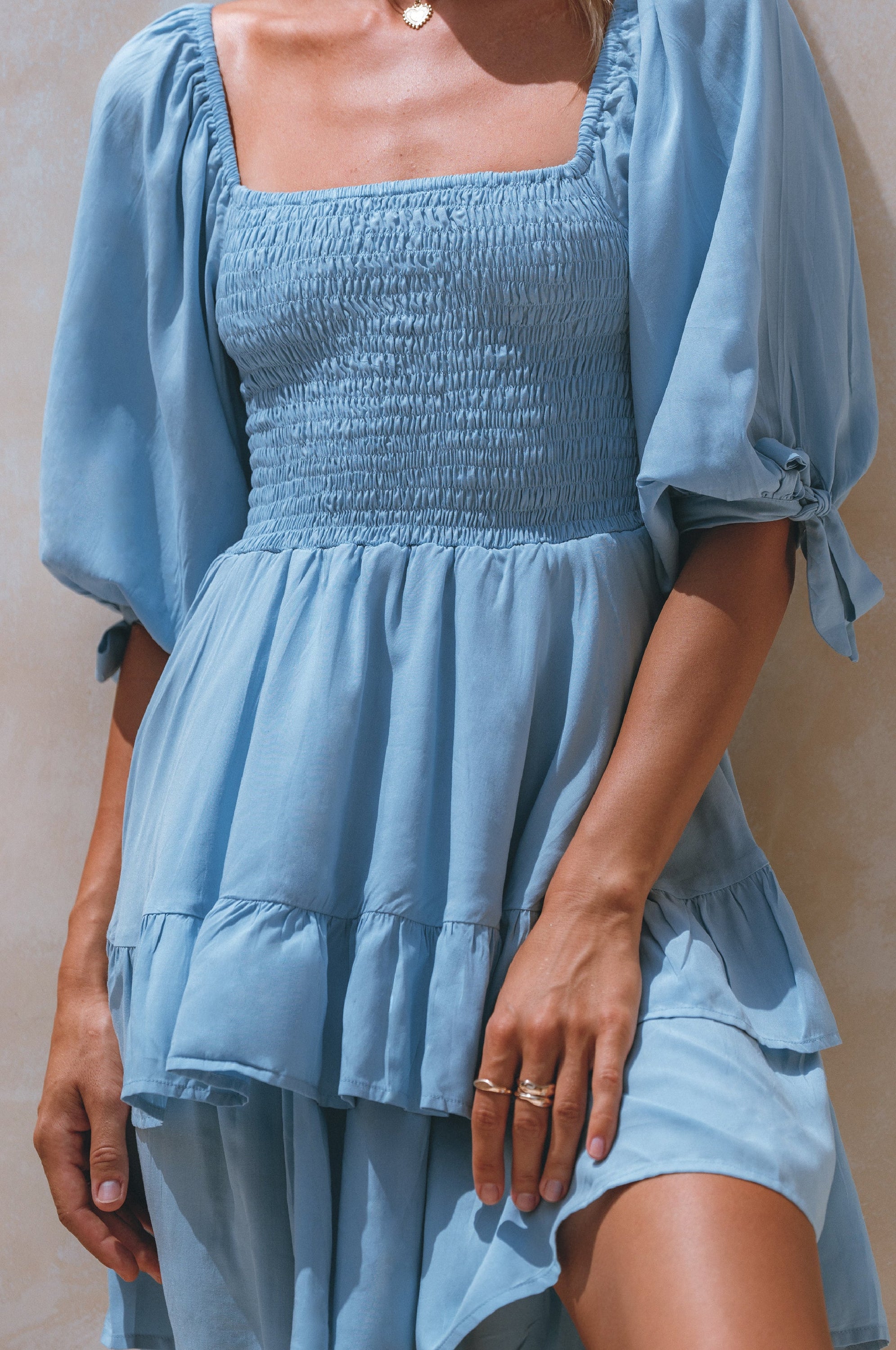 A stylish Cha-Cha Ruffle Mini Dress featuring a smocked bodice, ruffled trim, and billowing sleeves, perfect for summer outings.