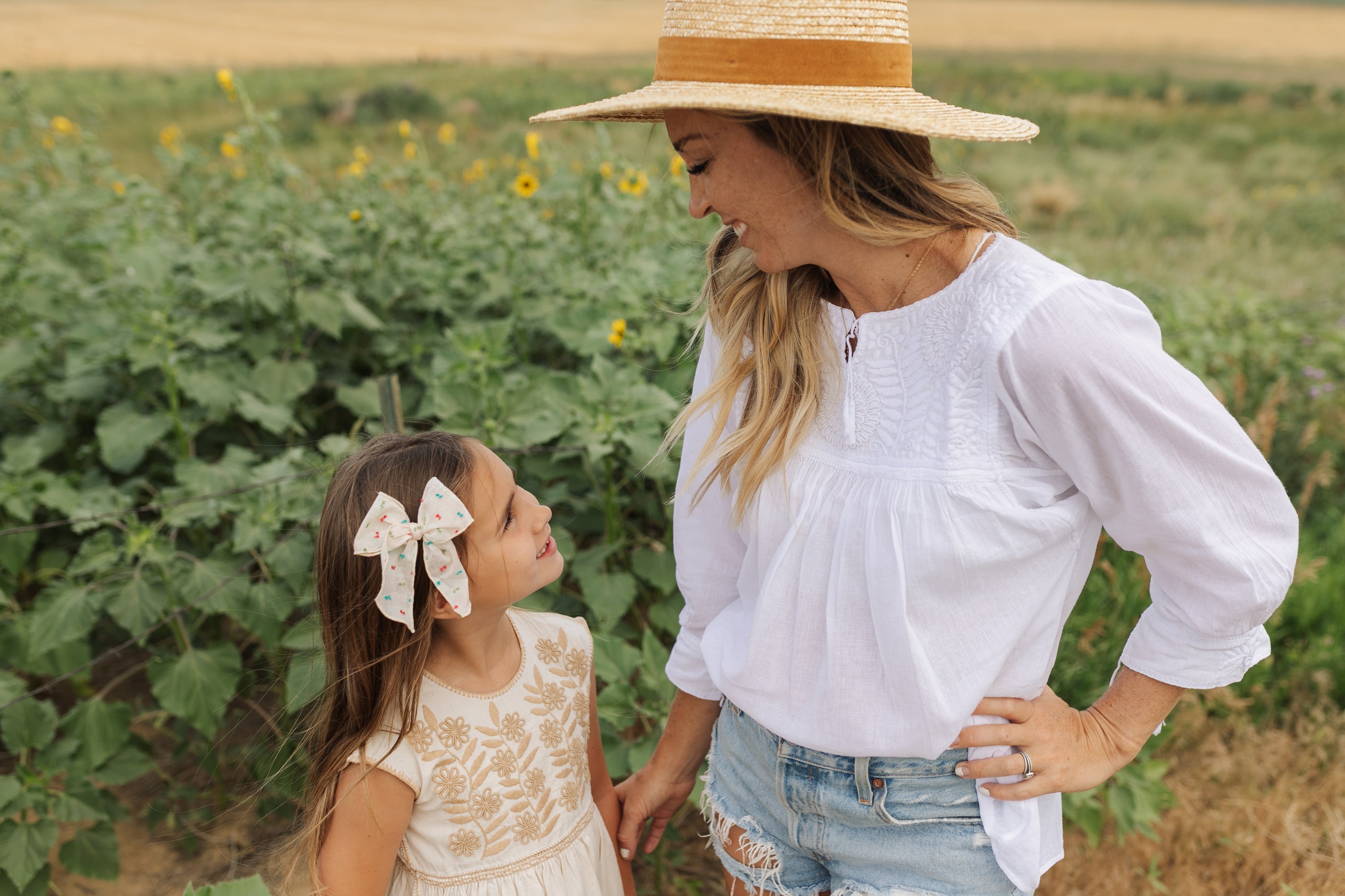 Chaya Blouse featuring white cotton fabric with intricate hand embroidery and tassel details on sleeves.