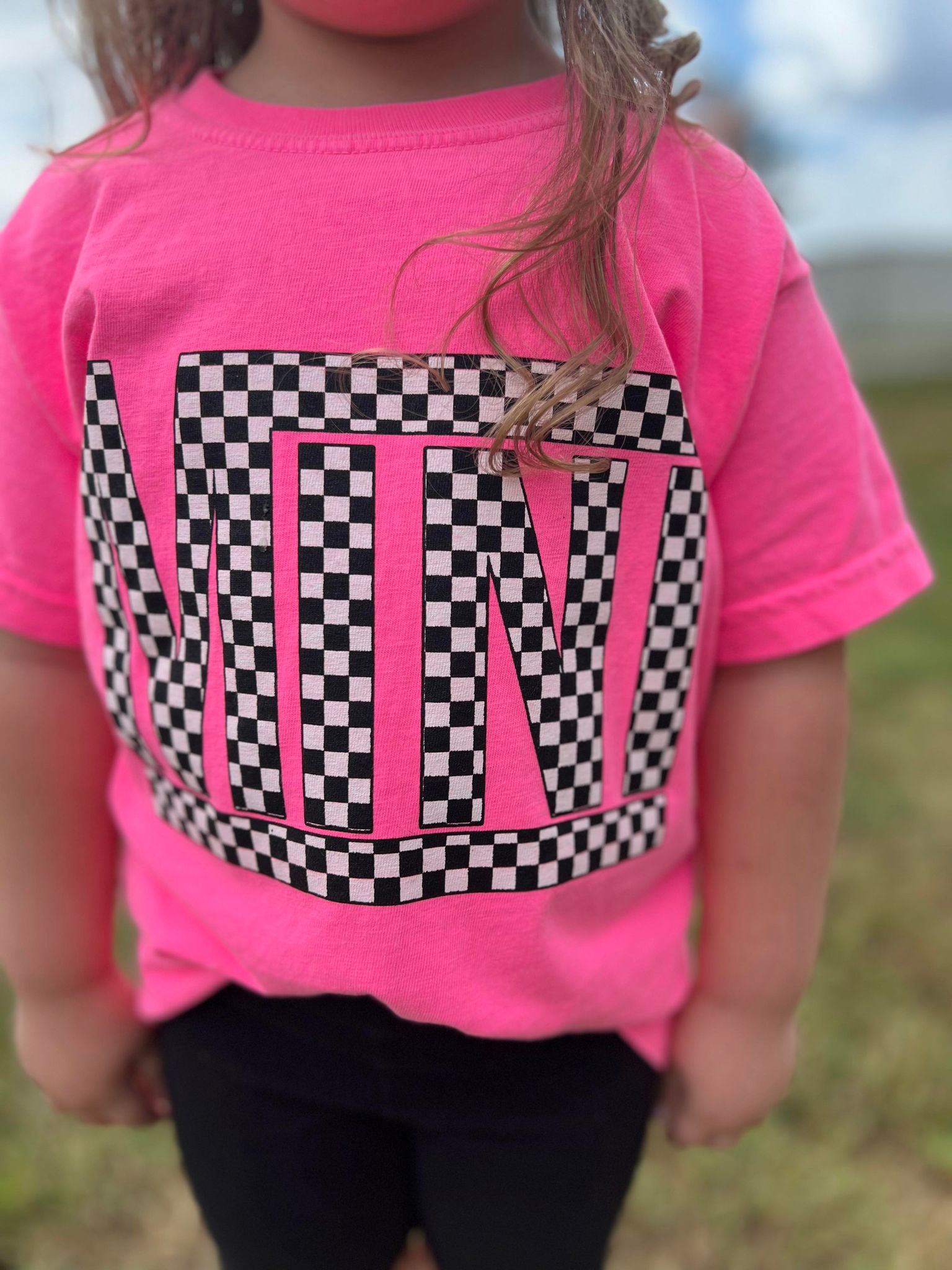 A vibrant neon pink checkered mini tee for youth, showcasing a stylish design perfect for matching outfits.