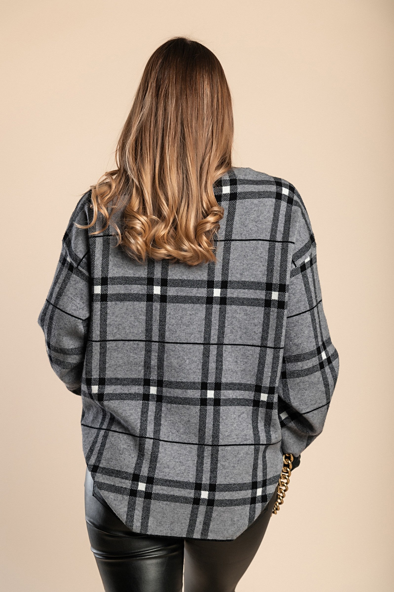 A cozy gray checkered sweater with long sleeves and a round neck, made from soft knit fabric, perfect for casual wear.