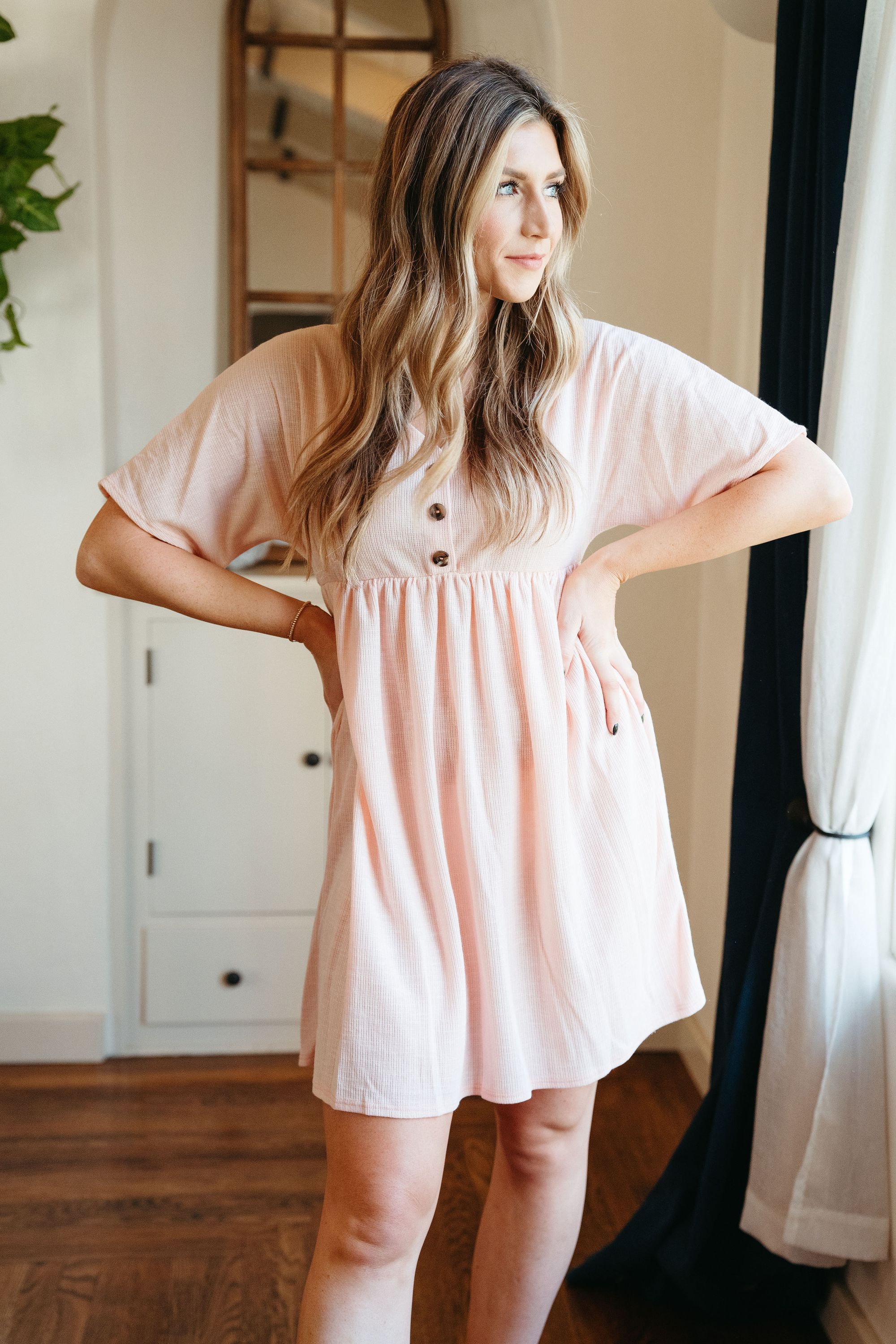 Chloe Dress in Blush featuring a delicate neckline and button details, perfect for spring styling.