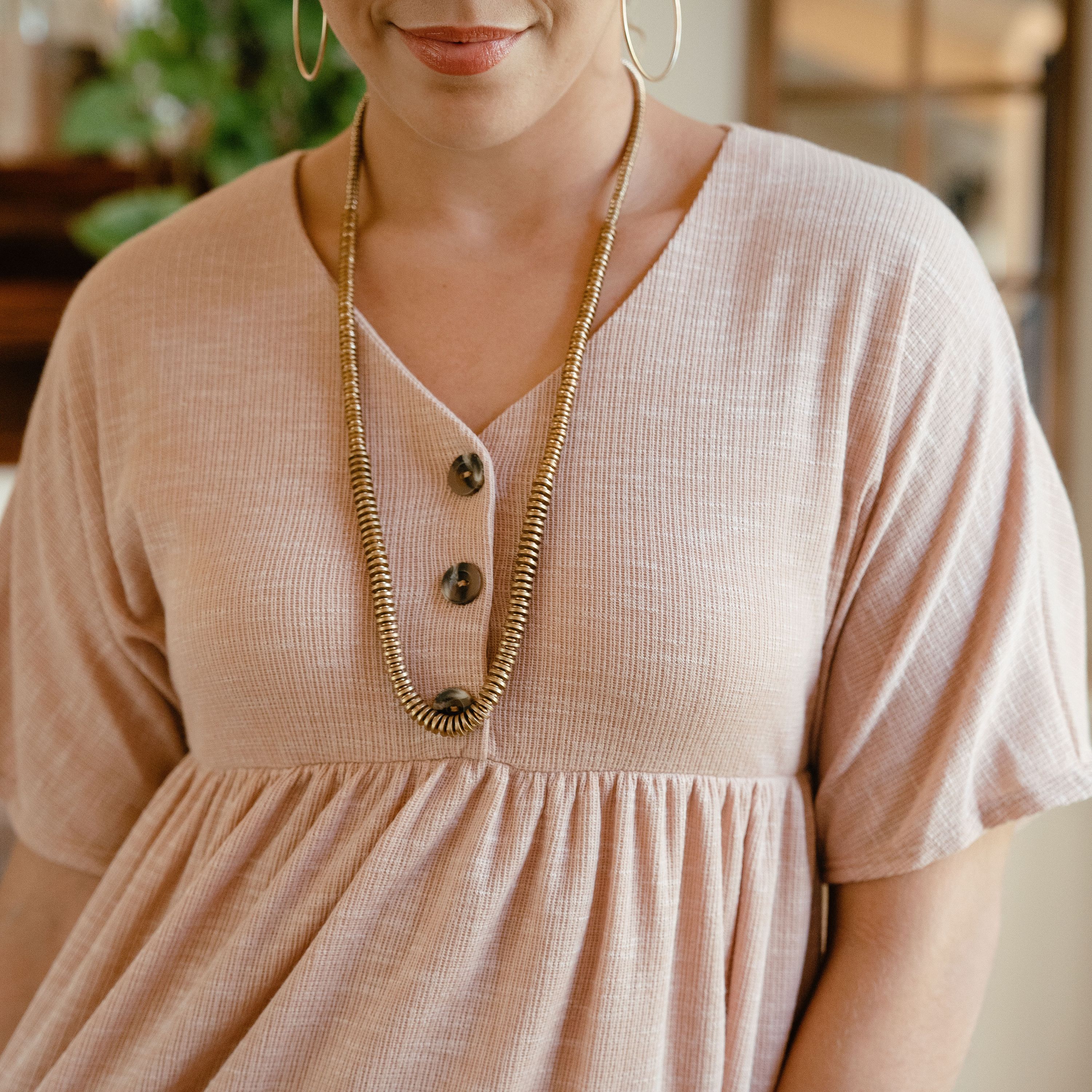 Chloe Dress in Taupe featuring a delicate neckline and button details, perfect for spring styling.