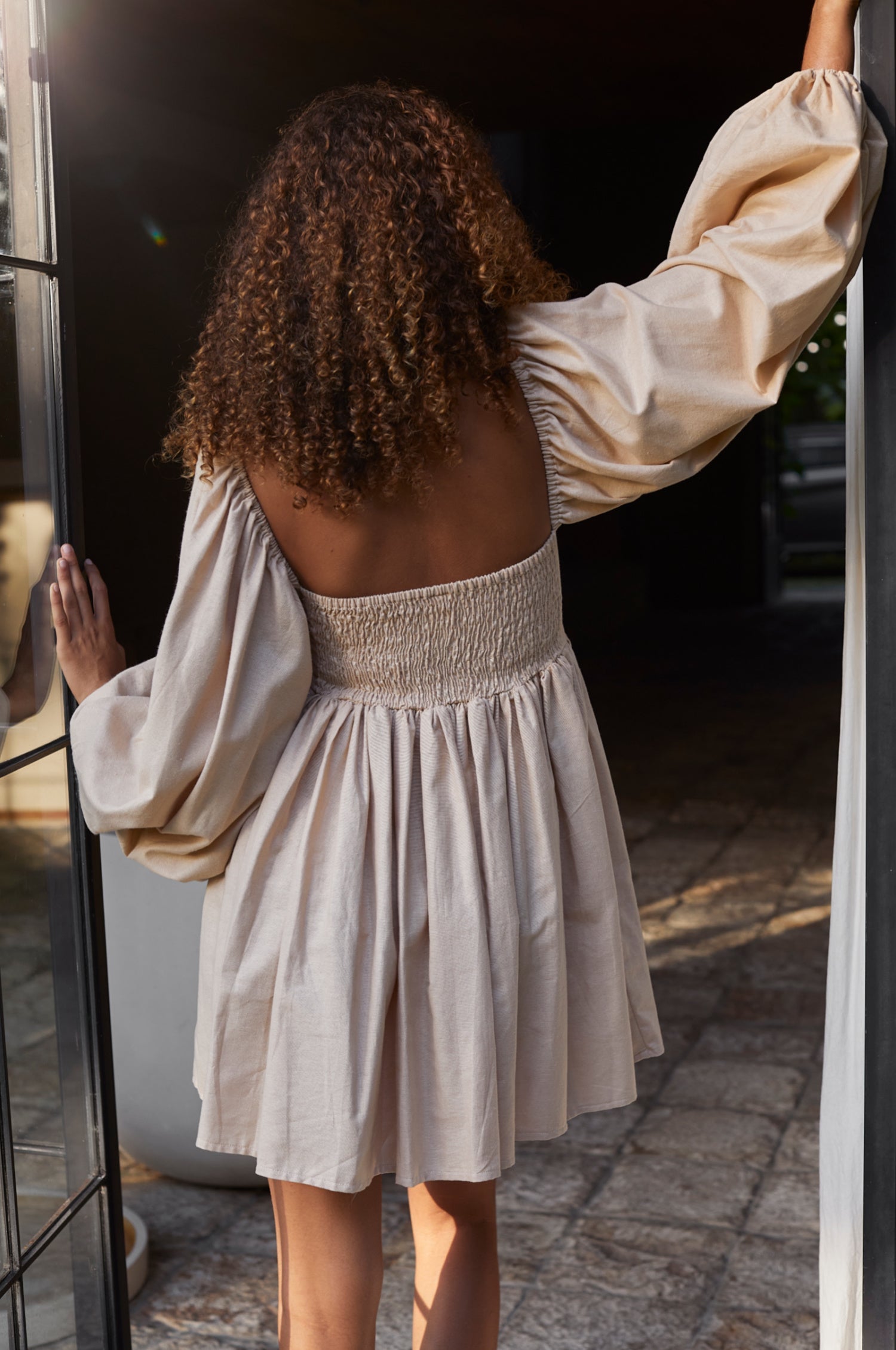 Chloie Empire Waist Linen Mini Dress featuring puff sleeves and a smocked back, displayed on a mannequin.