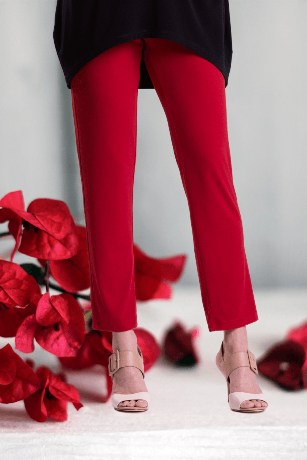 A pair of stylish red cigarette pants featuring a slim fit and elastic waistband, perfect for a comfortable and chic look.