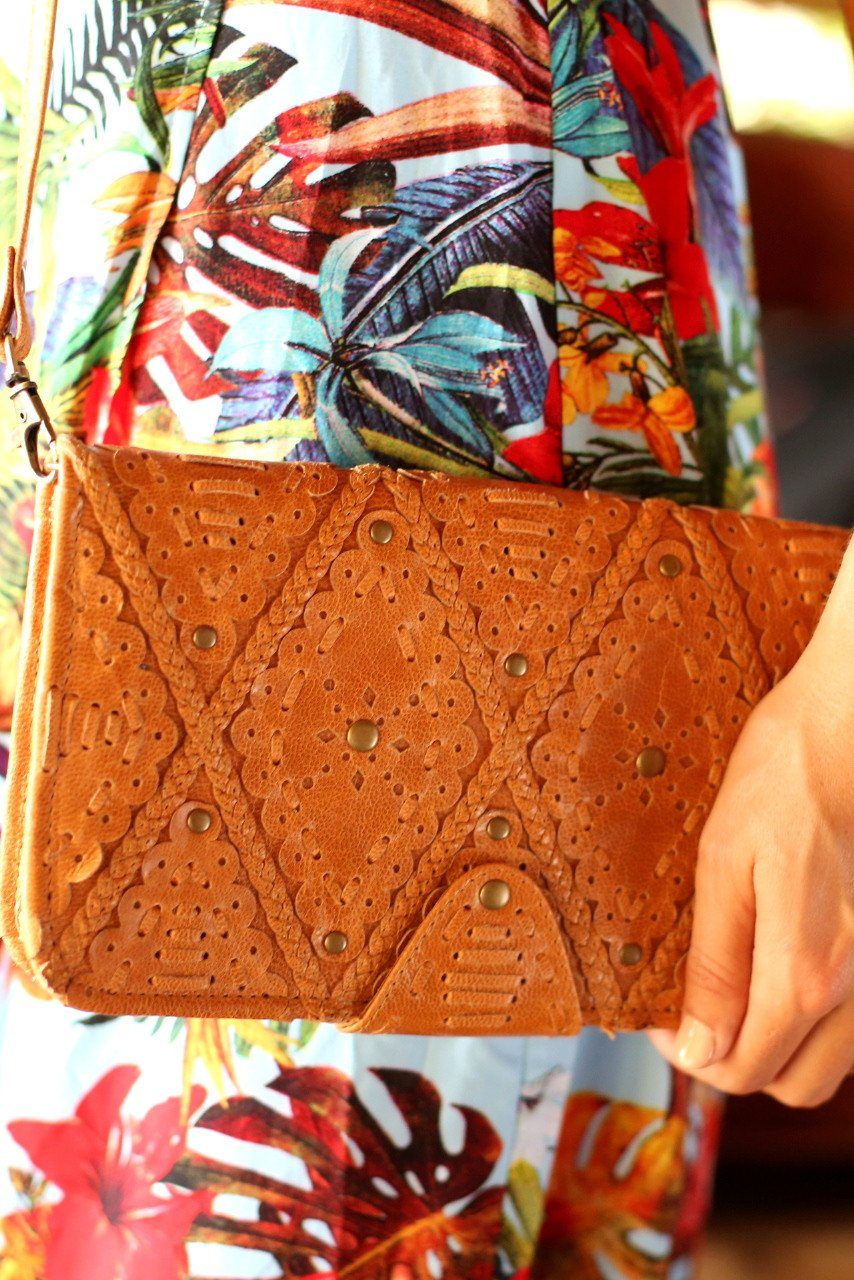 Colibri Leather Crossbody Clutch featuring intricate cut-out work and leather stitching, available in various colors.