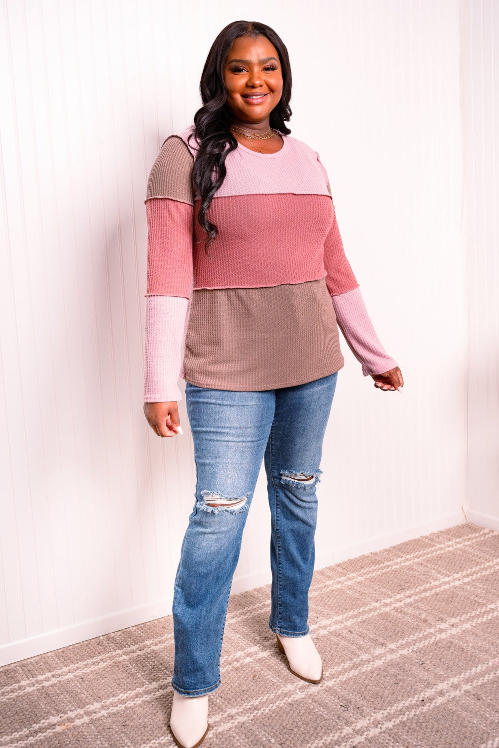 A stylish color block waffle-knit top featuring exposed seams, round neckline, and long sleeves, perfect for casual wear.