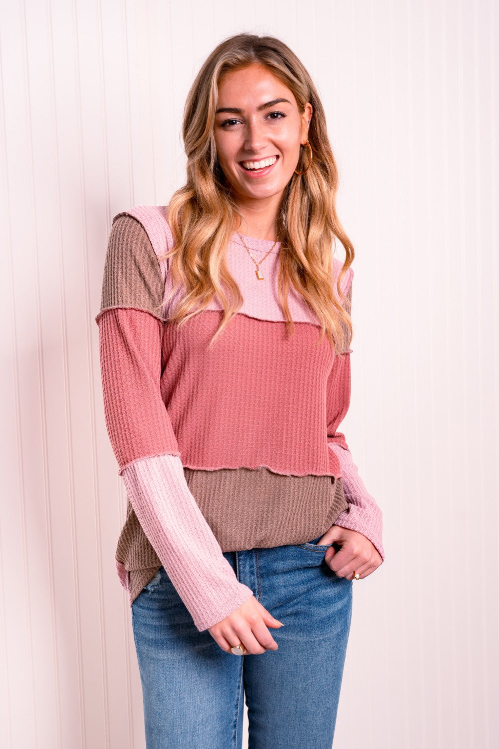 A stylish color block waffle-knit top featuring exposed seams, round neckline, and long sleeves, perfect for casual wear.