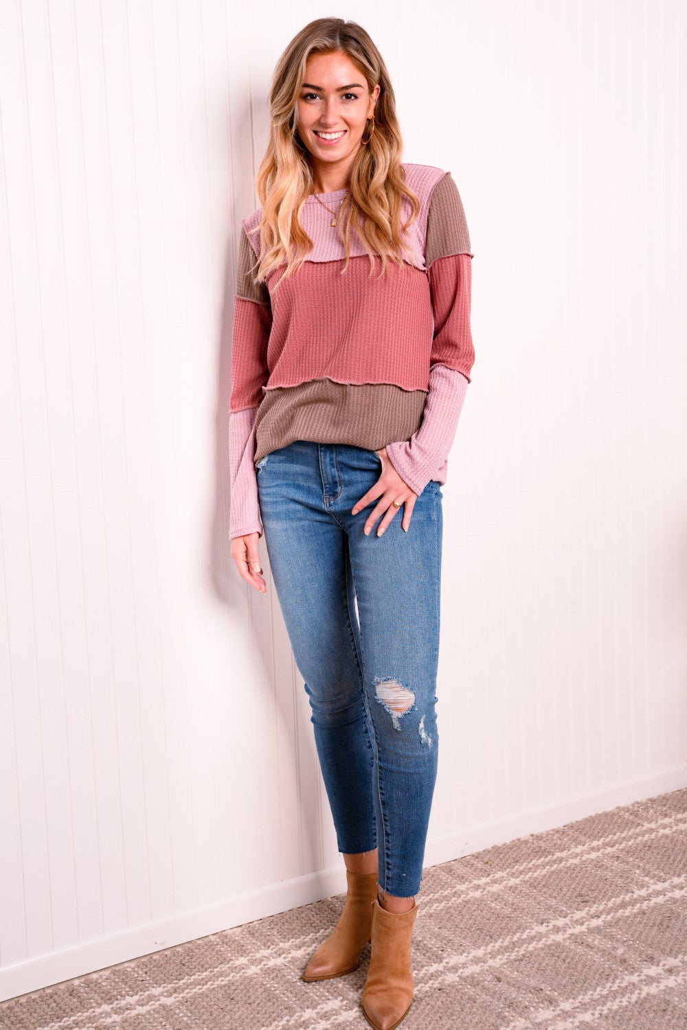 A stylish color block waffle-knit top featuring exposed seams, round neckline, and long sleeves, perfect for casual wear.