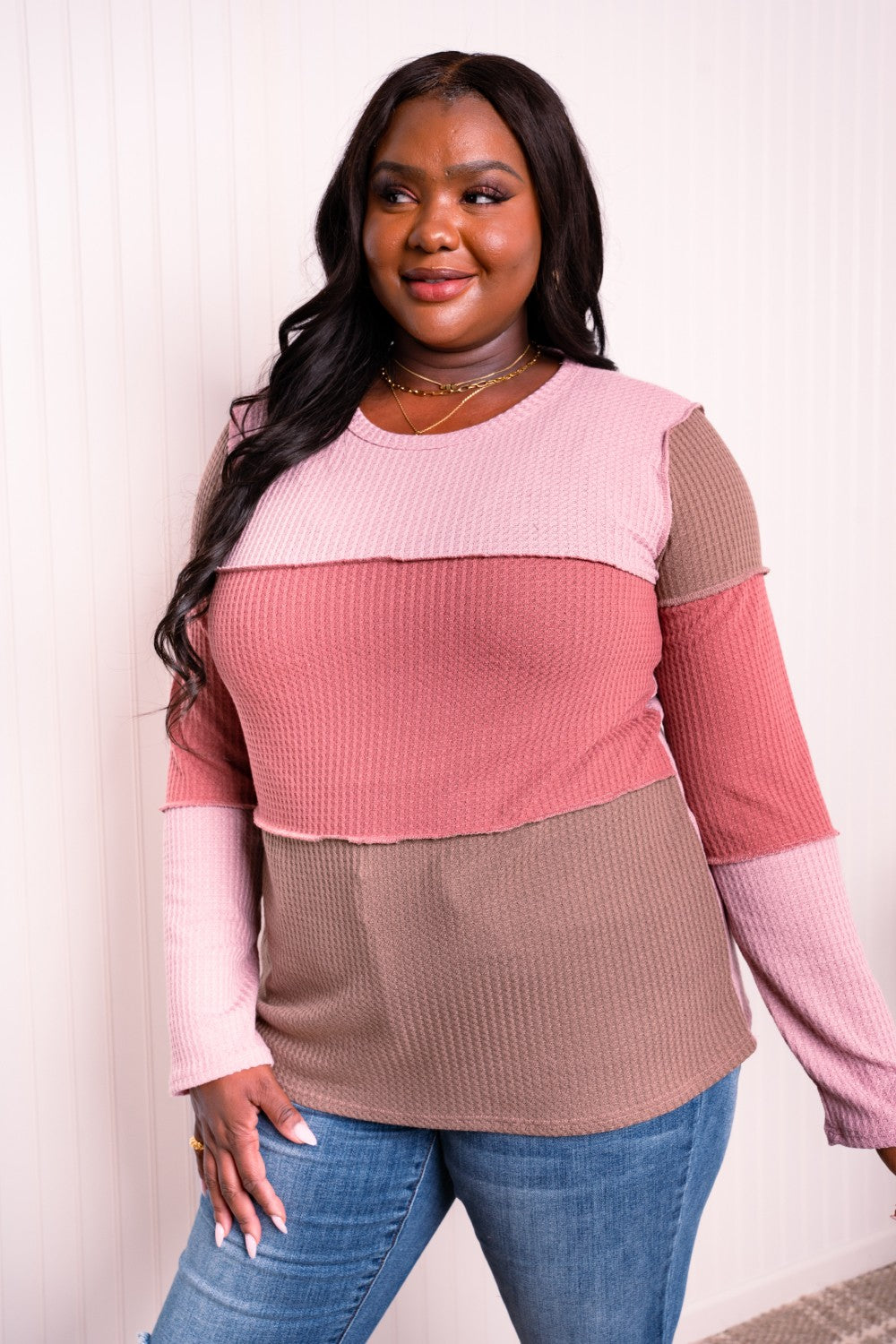 A stylish color block waffle-knit top featuring exposed seams, round neckline, and long sleeves, perfect for casual wear.