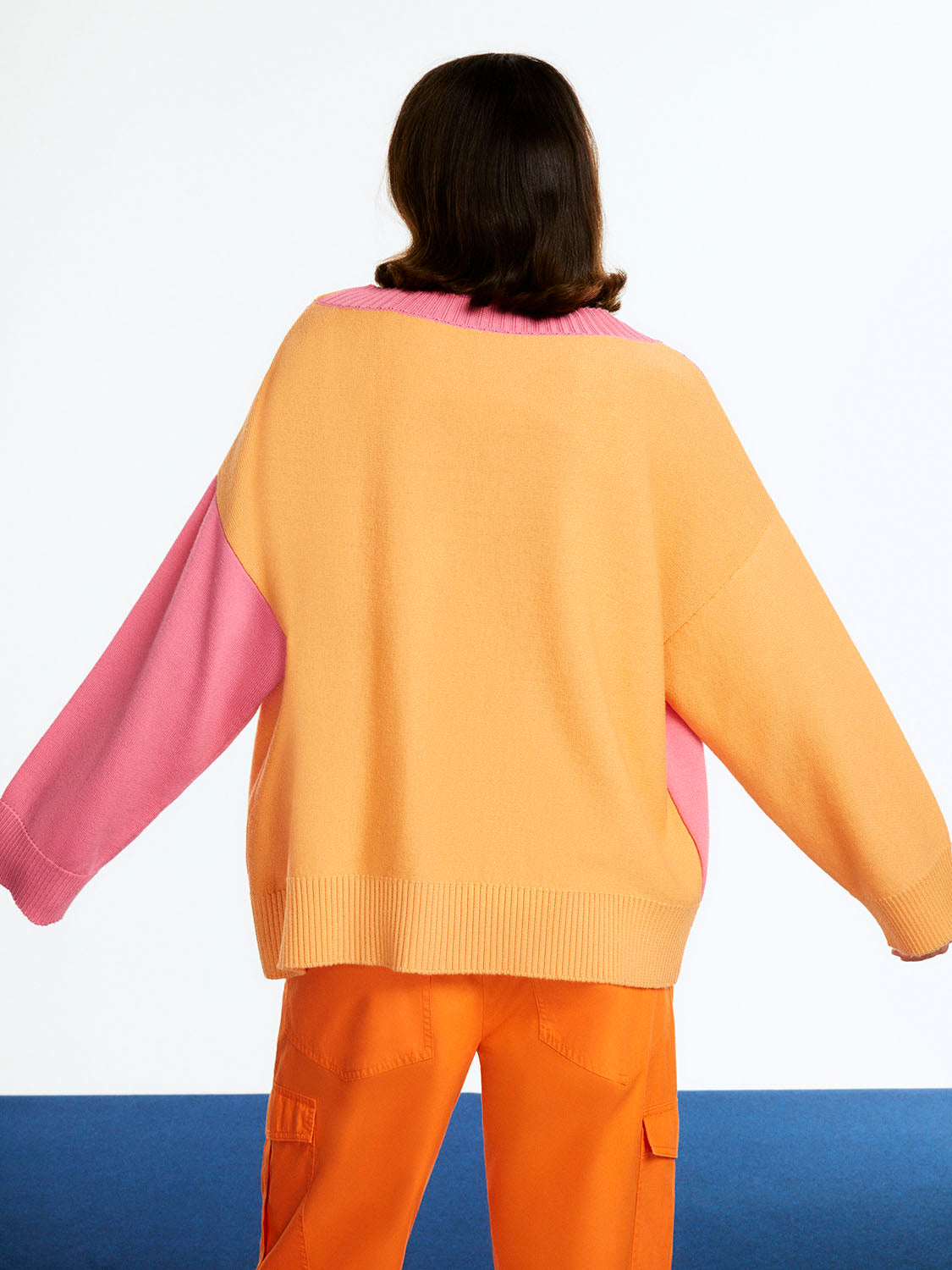 Color Block Knit Cardigan featuring vibrant orange, pink, and blue hues with a slouchy fit and long sleeves.