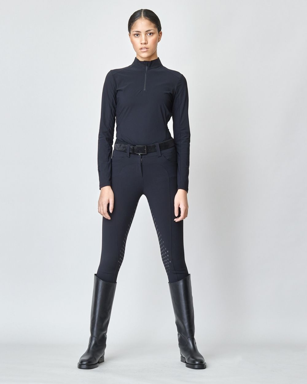 A pair of black Compression Performance Breeches featuring a sleek design, belt loops, and two front pockets, ideal for equestrian activities.