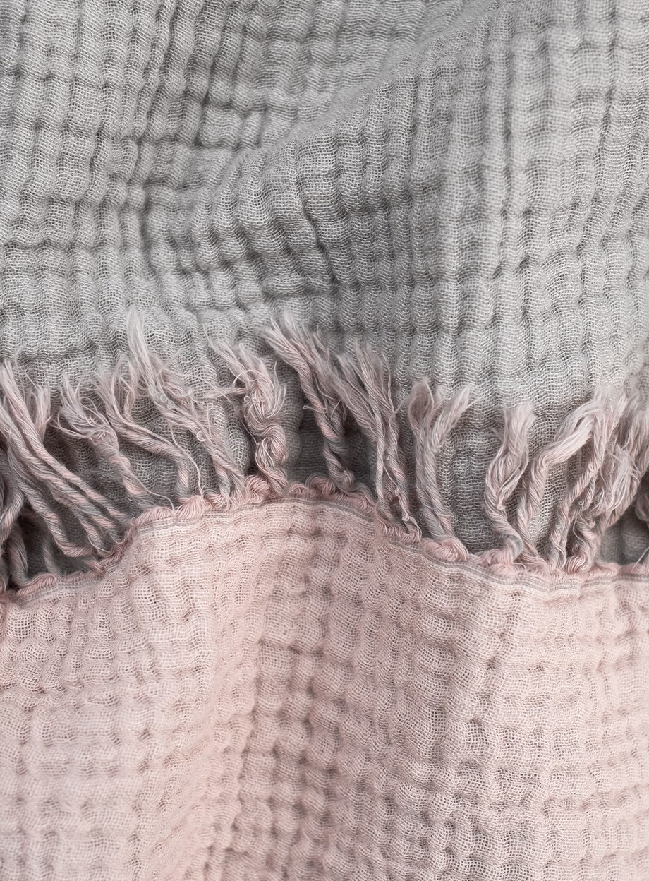 A cozy Cotton Throw Blanket in powder pink and gray, showcasing its double-sided design and soft texture, perfect for couch or beach use.