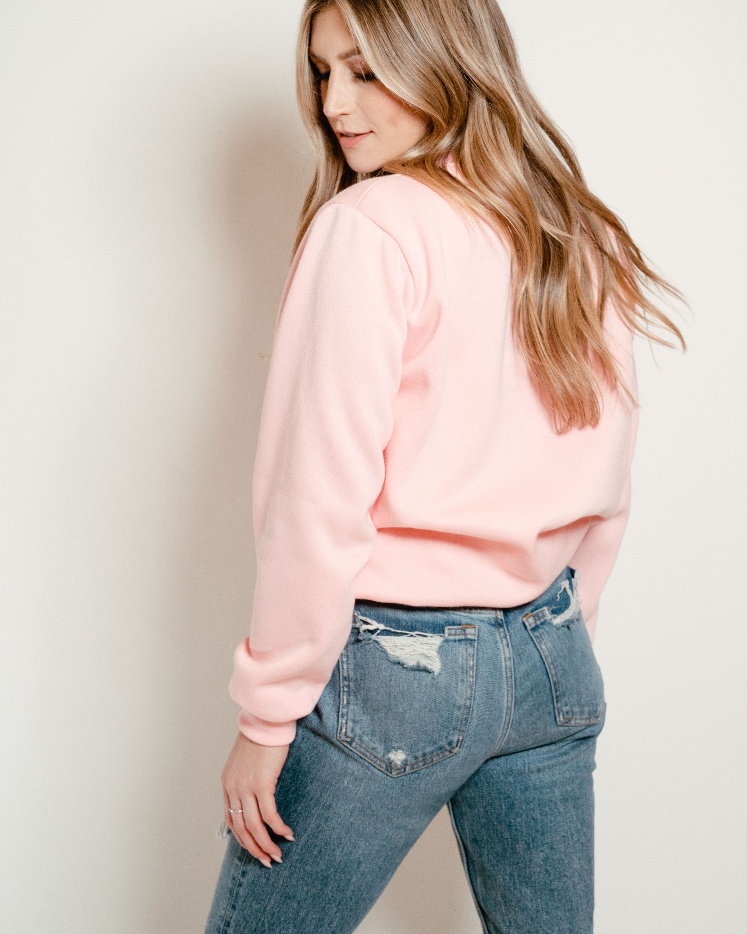 A soft pink crew neck sweatshirt, perfect for casual wear, featuring a comfortable fit and stylish design.