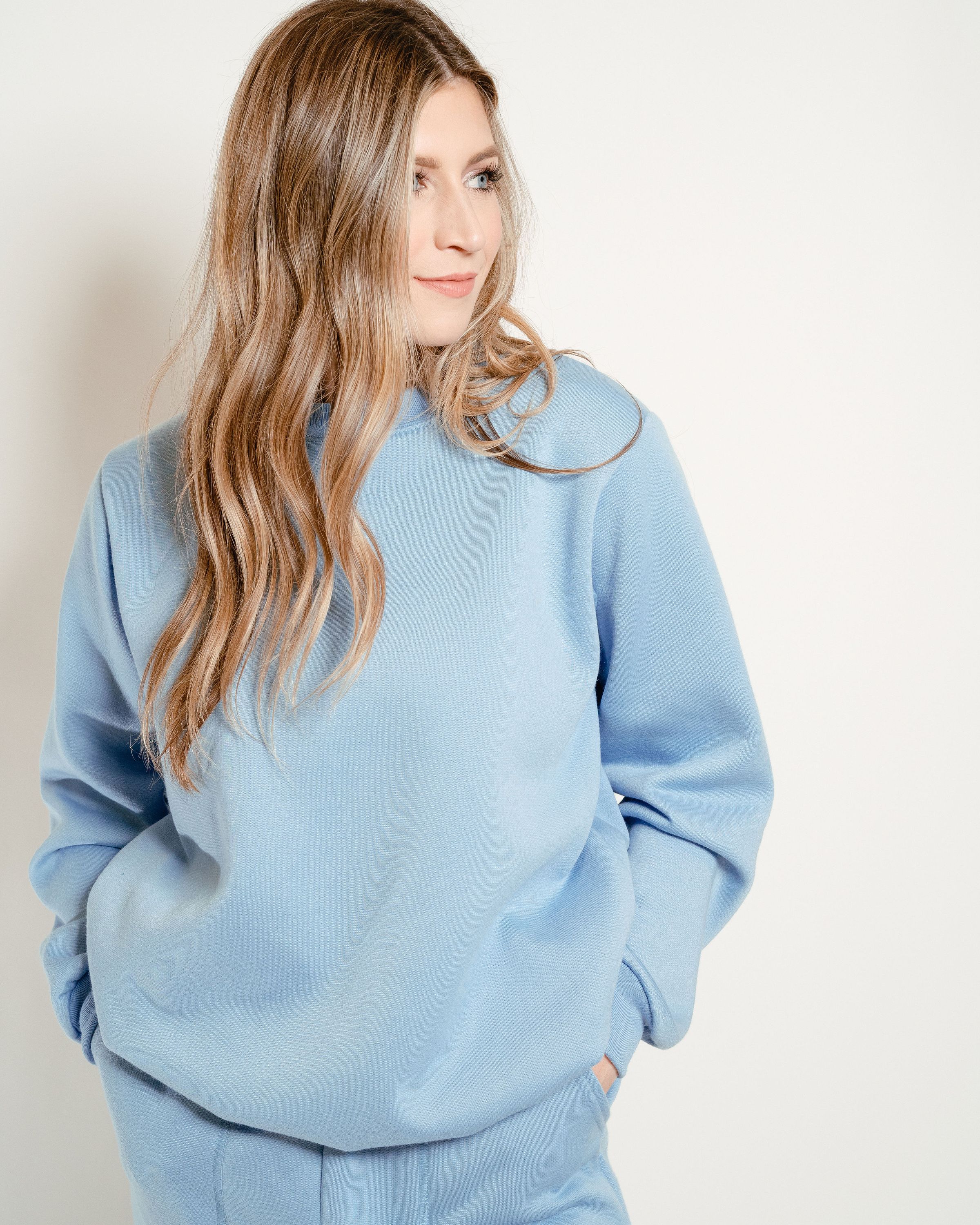 Sky Blue Crew Neck Sweatshirt displayed on a hanger, showcasing its soft fabric and classic design.