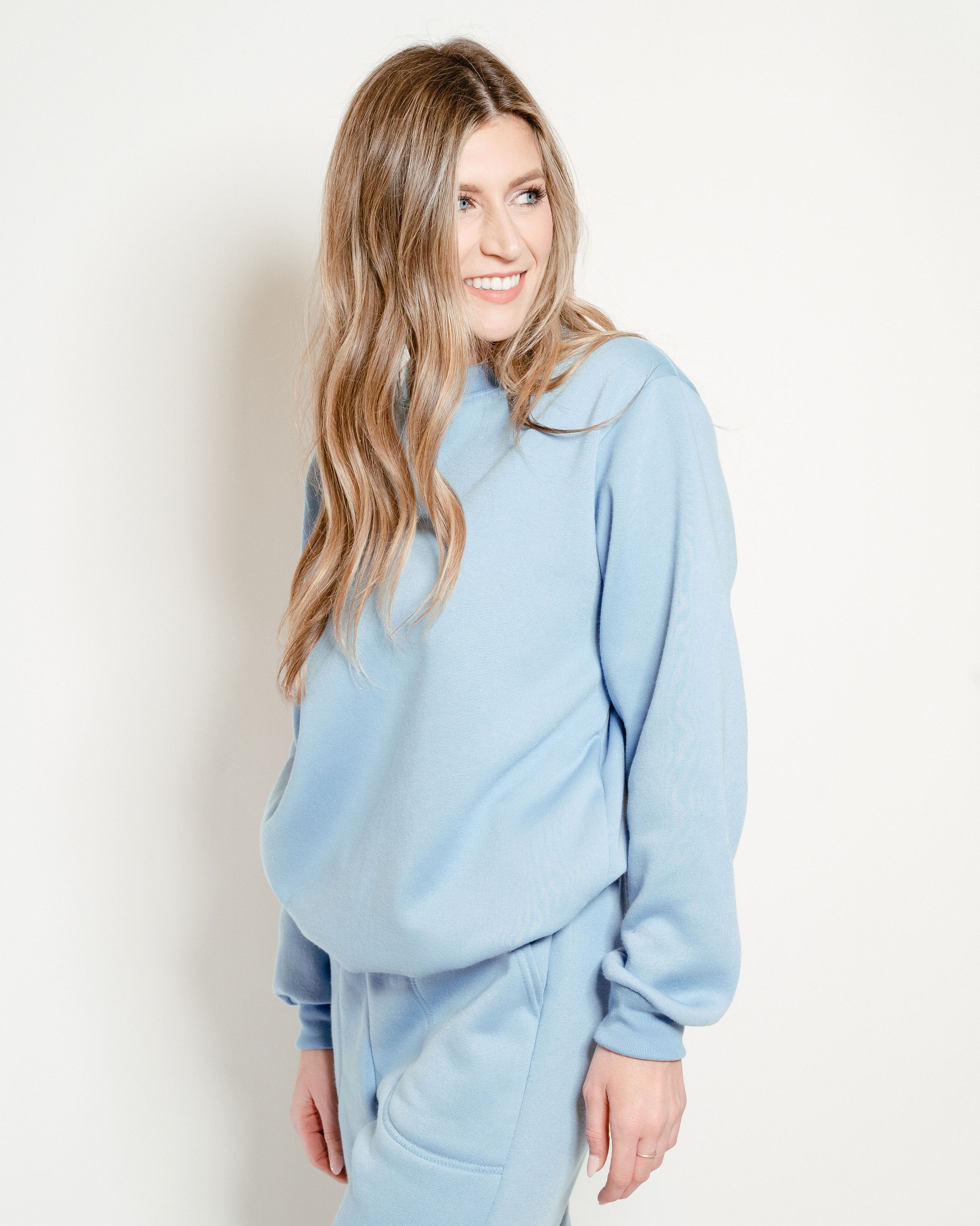 Sky Blue Crew Neck Sweatshirt displayed on a hanger, showcasing its soft fabric and classic design.