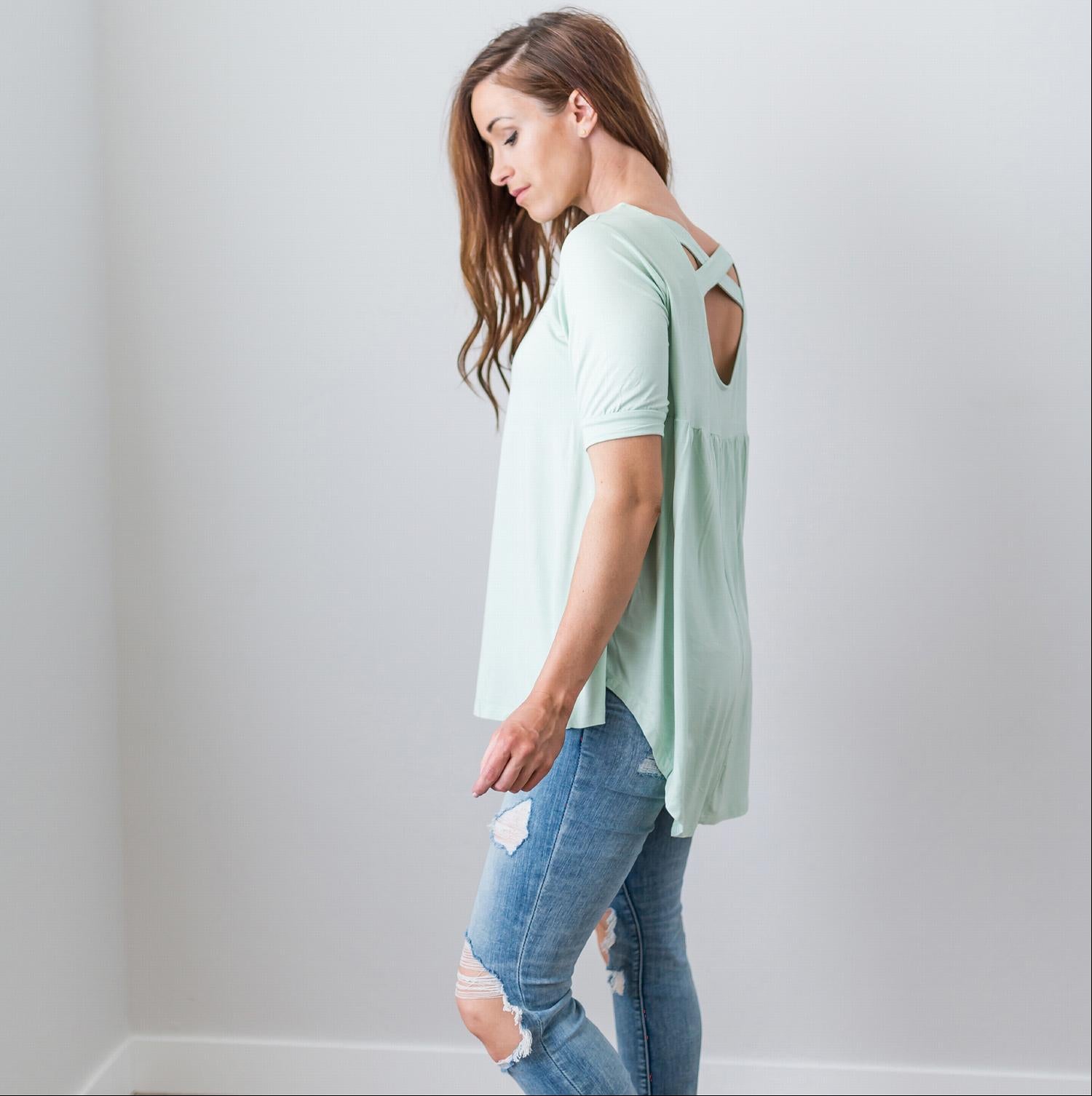 A stylish Criss Cross Back Hi-Low Scoop Hem Top in soft fabric, featuring three-quarter sleeves and a flattering fit, perfect for spring and summer wear.