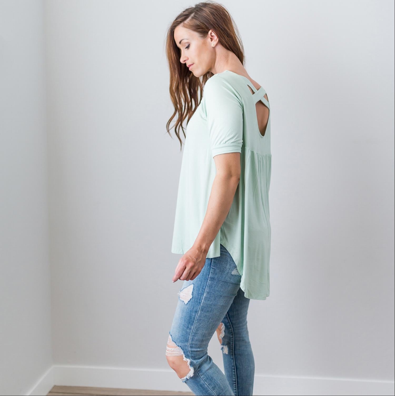 A stylish Criss Cross Back Hi-Low Scoop Hem Top in soft fabric, featuring three-quarter sleeves and a flattering fit, perfect for spring and summer wear.