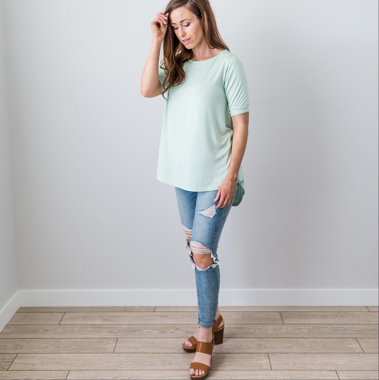 A stylish Criss Cross Back Hi-Low Scoop Hem Top in soft fabric, featuring three-quarter sleeves and a flattering fit, perfect for spring and summer wear.