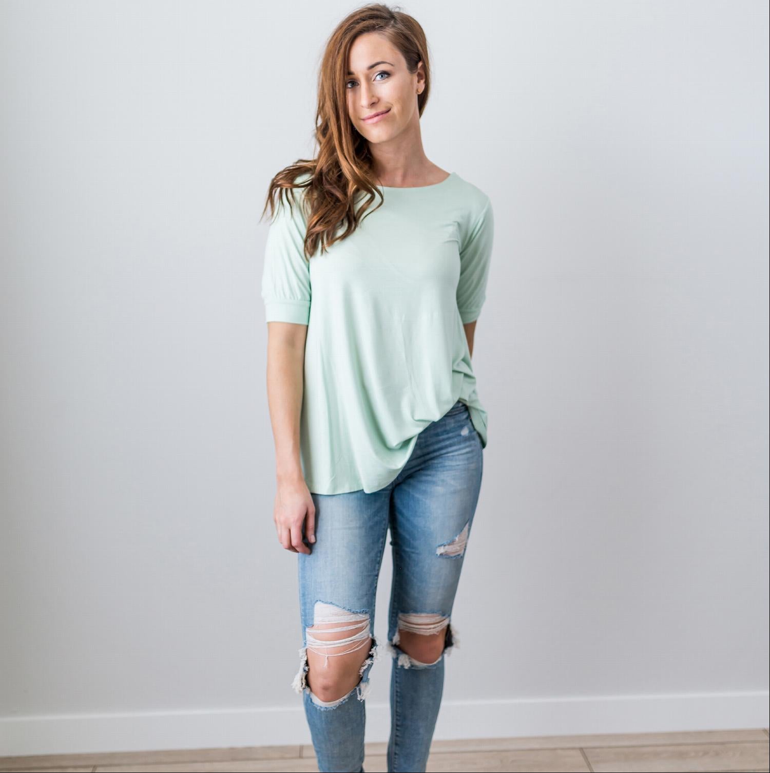 A stylish Criss Cross Back Hi-Low Scoop Hem Top in soft fabric, featuring three-quarter sleeves and a flattering fit, perfect for spring and summer wear.