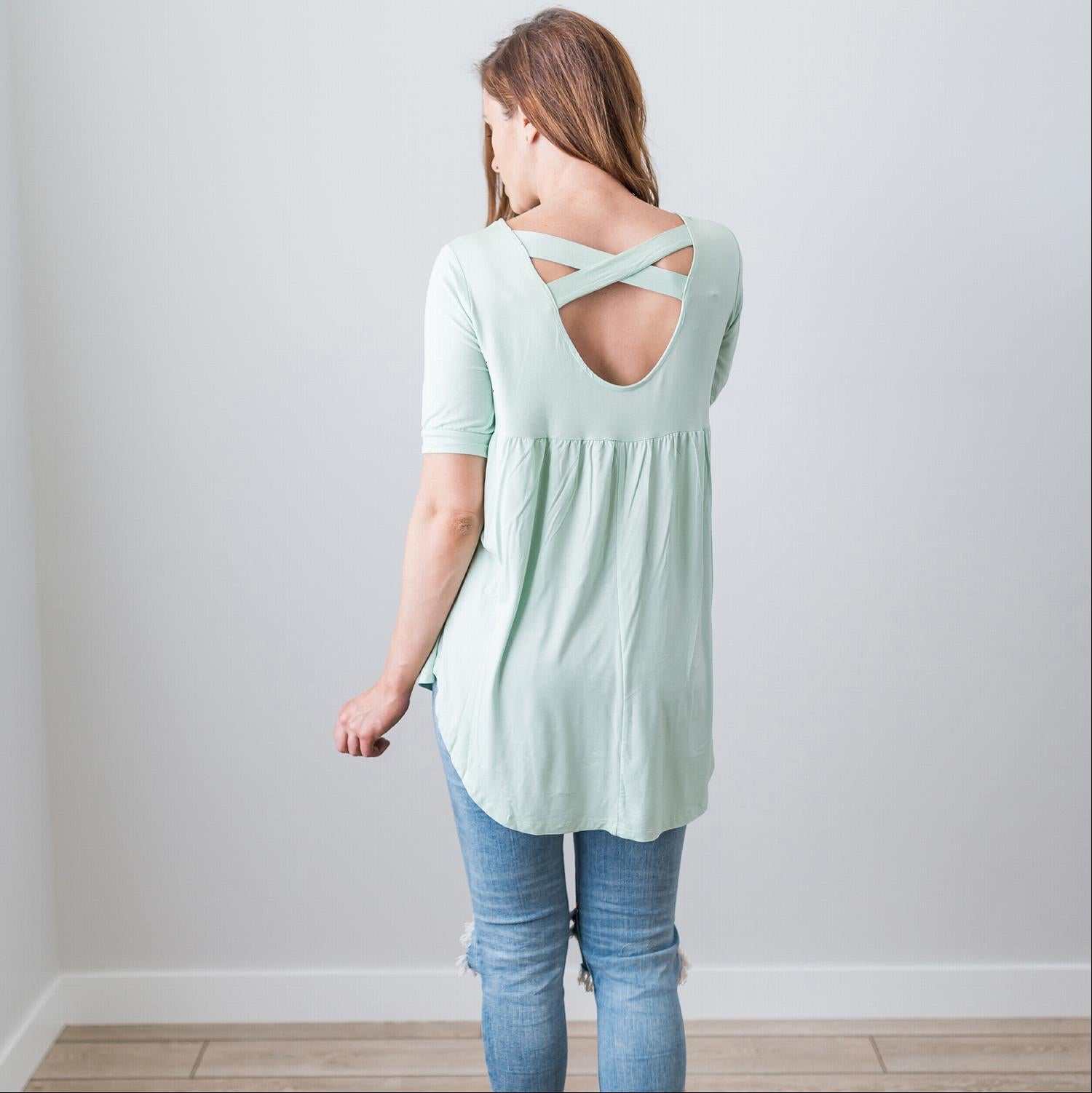 A stylish Criss Cross Back Hi-Low Scoop Hem Top in soft fabric, featuring three-quarter sleeves and a flattering fit, perfect for spring and summer wear.